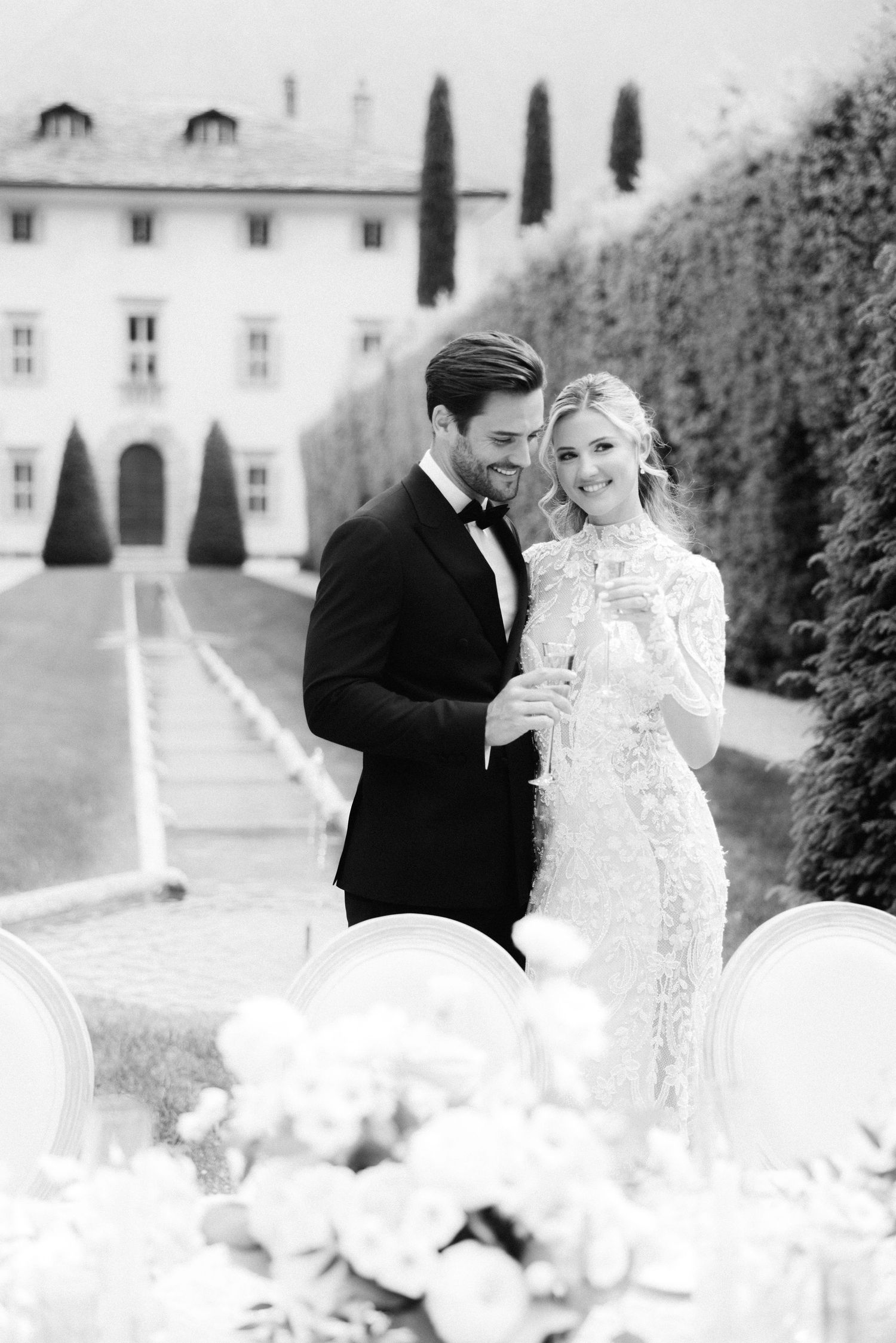 A romantic black and white wedding photo series showing a couple embracing in an elegant garden setting.