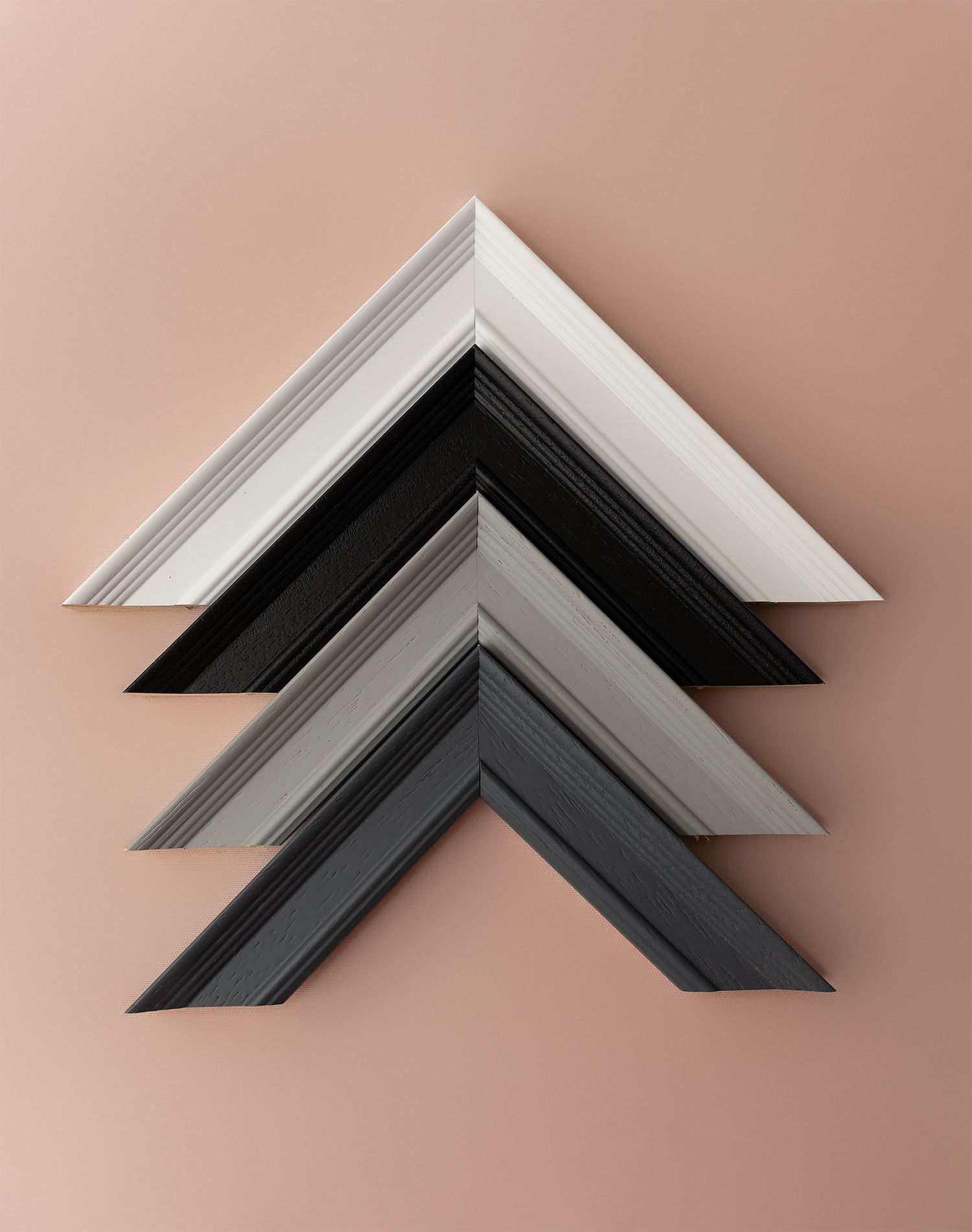 A series of black and white picture frame corners arranged in a gradient pattern against a pink background.