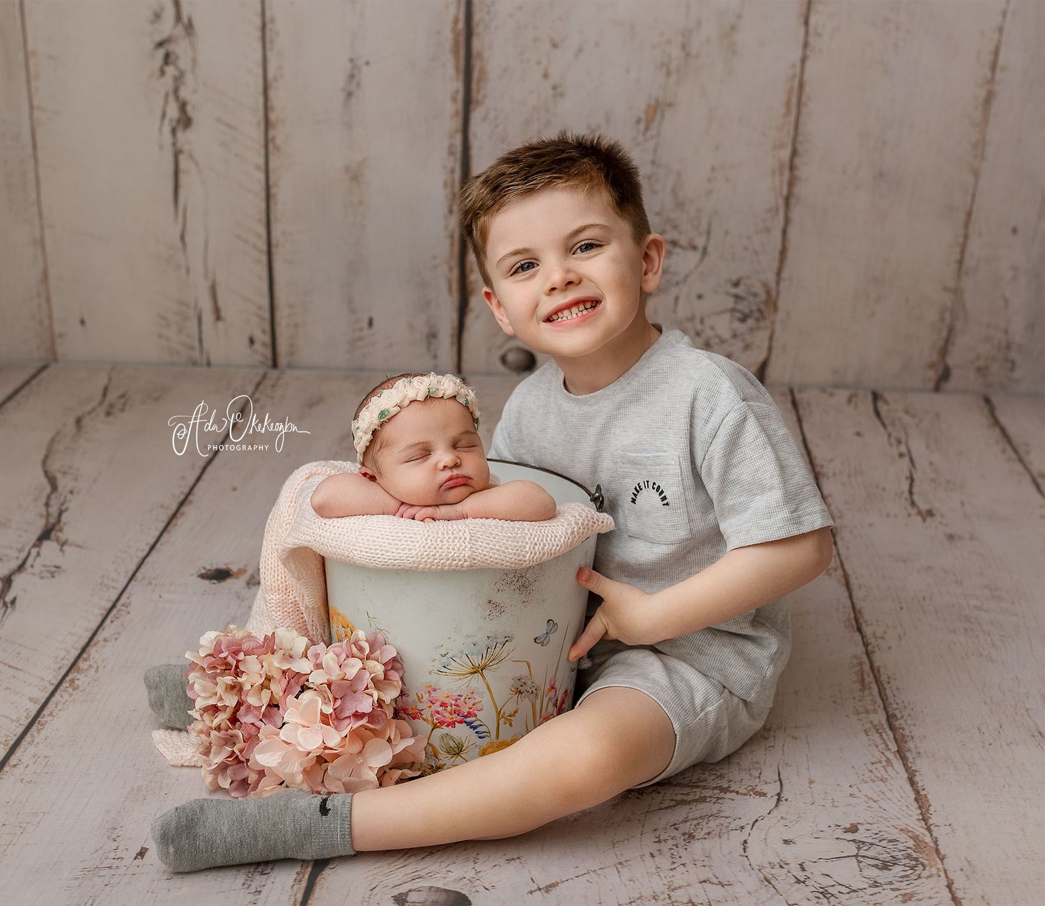 A tender moment between a newborn baby girl and her big brother capturing sibling love, connection and timeless family memories.