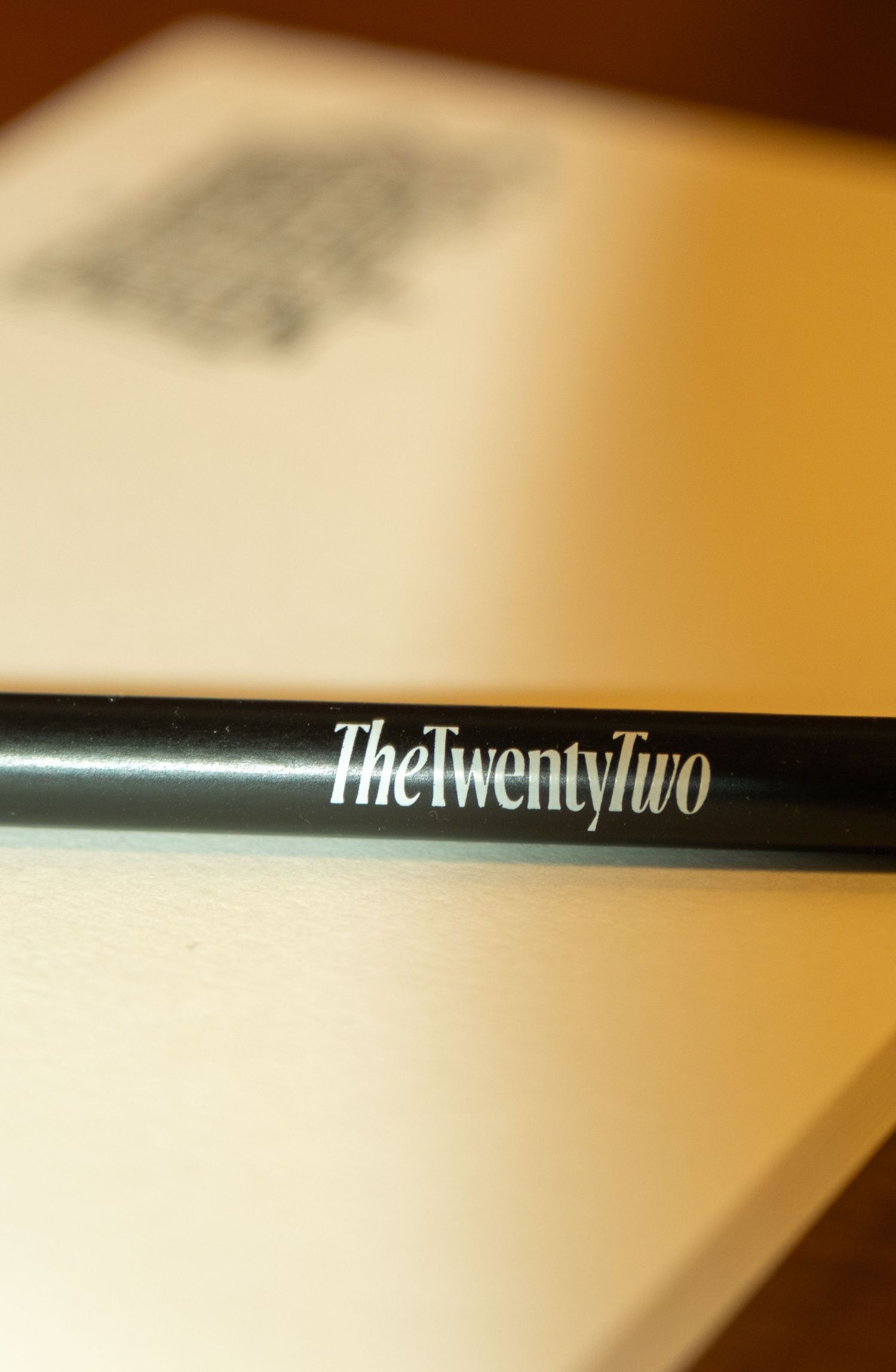 Close-up of a black pen engraved with The Twenty Two luxury hotel branding.