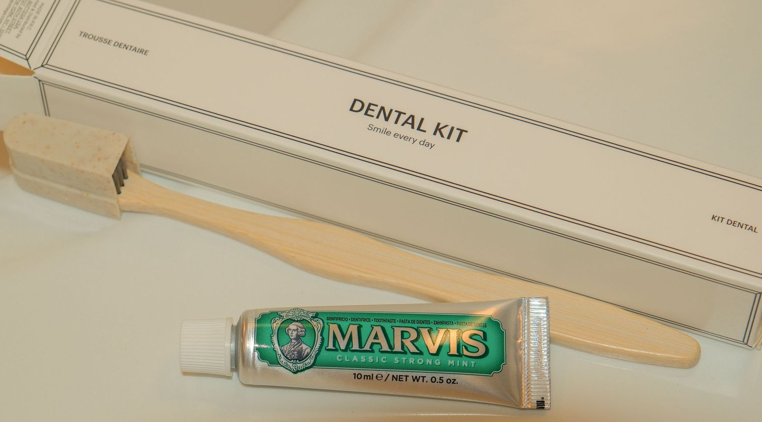 Marvis toothpaste and wooden toothbrush in a luxury hotel dental kit box amenity.