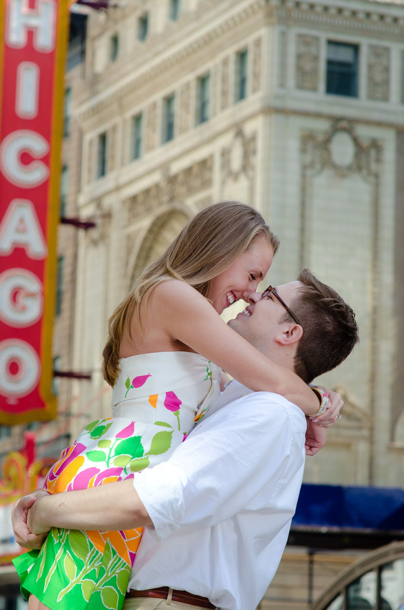 A romantic moment captured outside the Chicago Theatre with its iconic sign visible in the background.