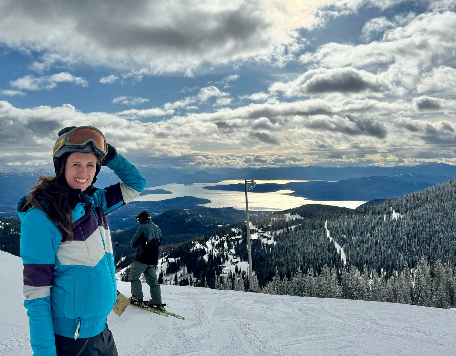 Winter sports enthusiast overlooking snowy mountain landscape from ski resort summit.