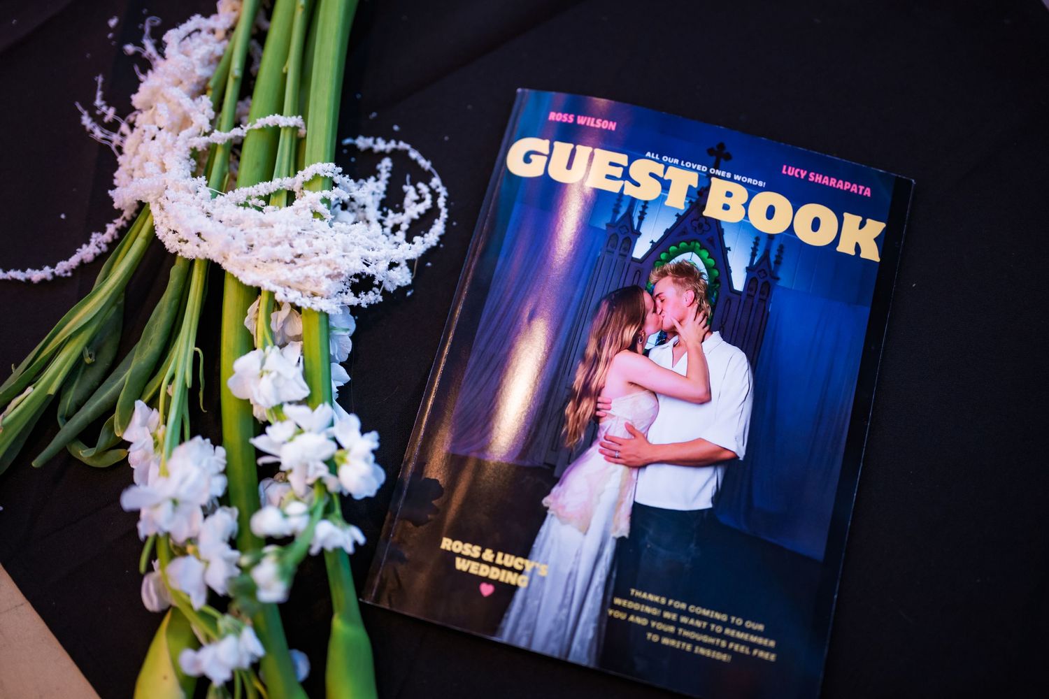 Wedding guest book designed like a magazine cover with couple dancing photo on dark background.
