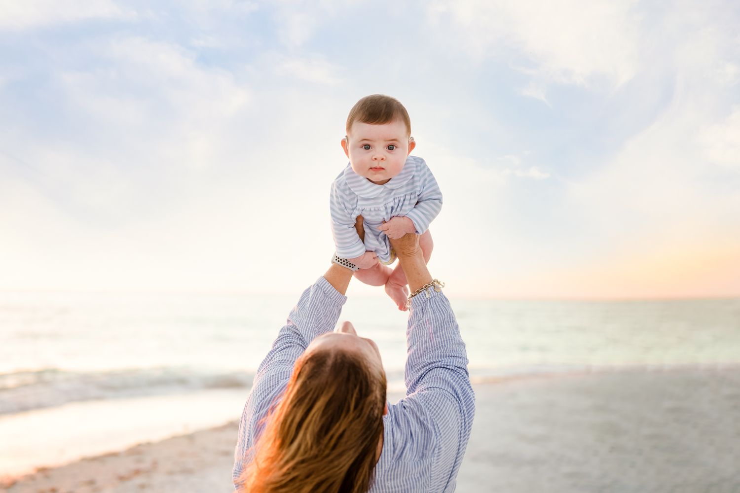 A mother and baby share tender moments at sunset on a sandy beach, captured in a series of candid photos.