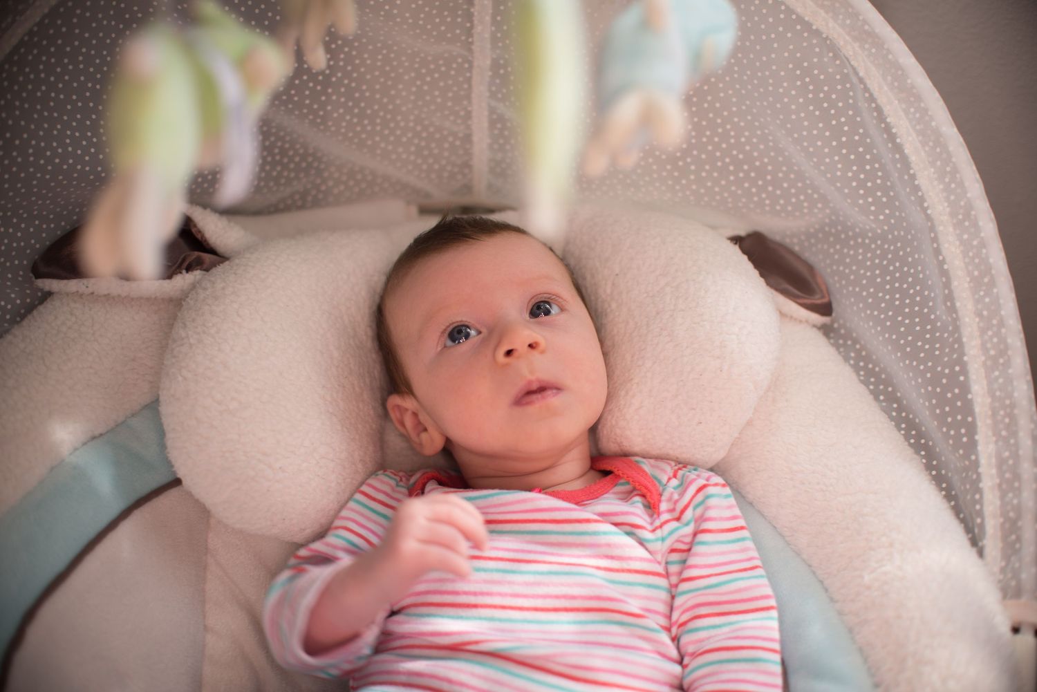 A series of tender newborn baby portraits showing sweet expressions while resting on white fabric.