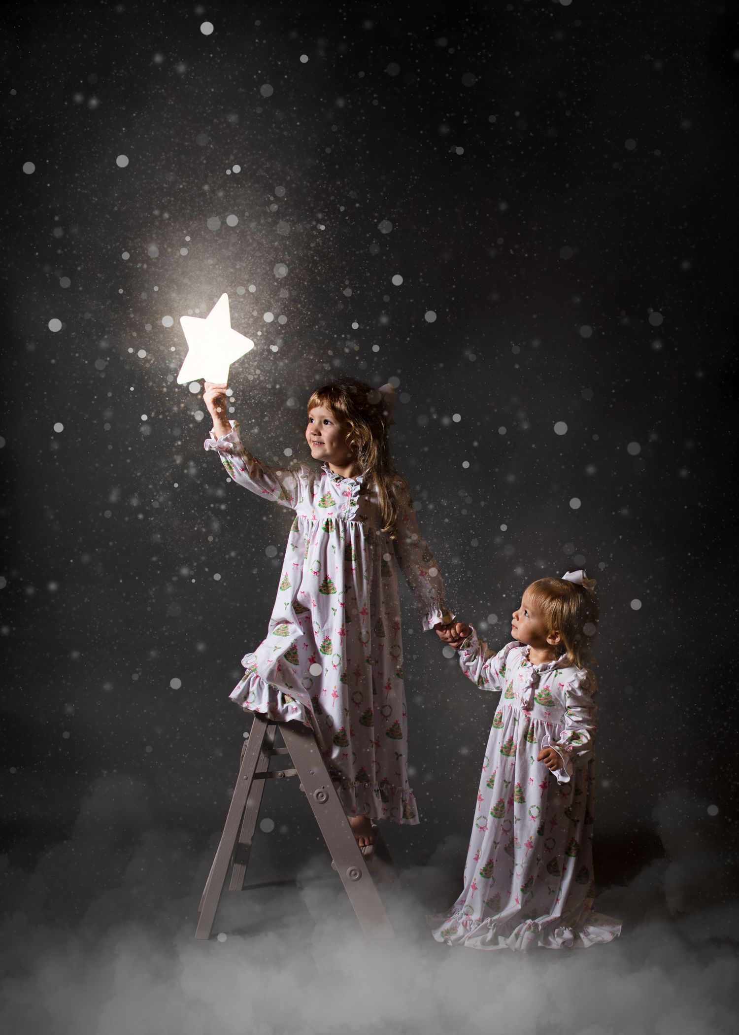 Whimsical scene of figures placing stars in night sky with falling snow effect.