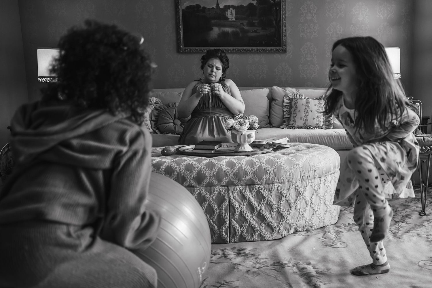 Children playing and crawling on furniture in black and white.