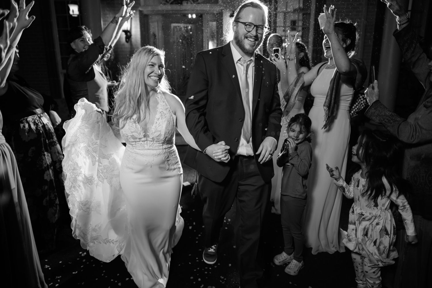 Wedding guests dance and celebrate on a crowded dance floor at an evening reception.