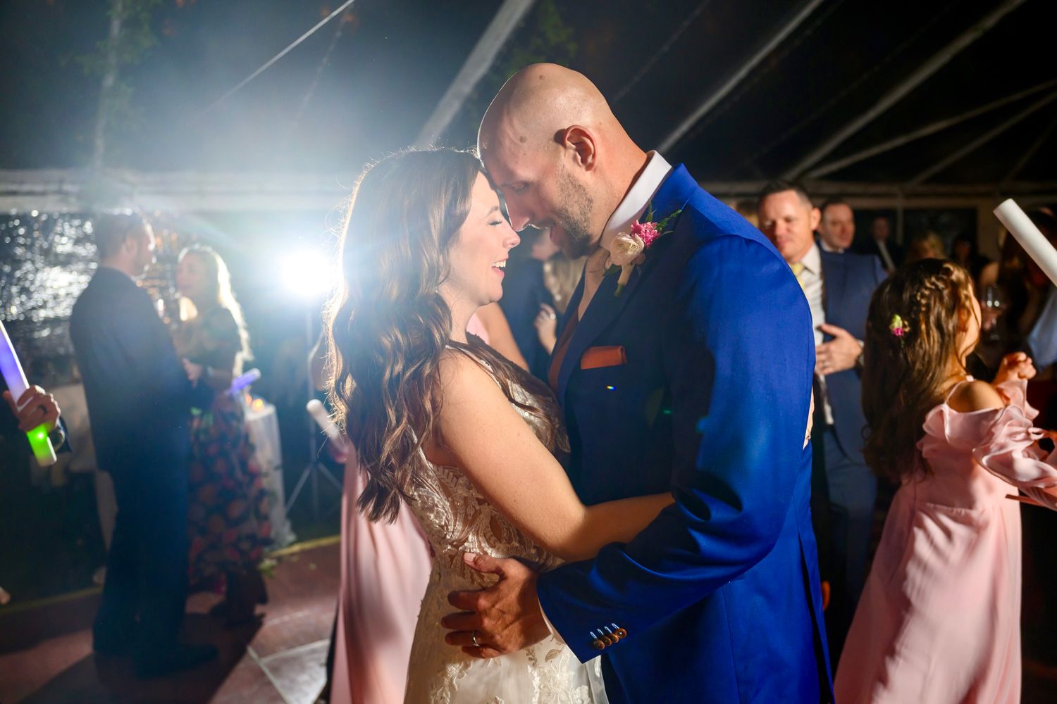 A couple shares their first dance at a wedding reception under twinkling lights on the dance floor.