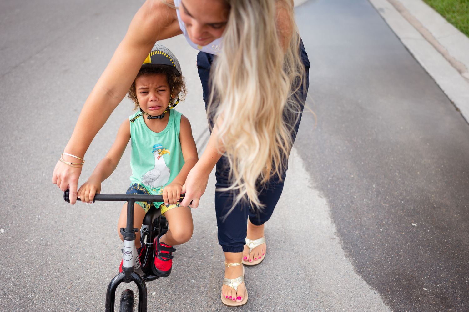Children riding scooters on a paved pathway during an outdoor activity.