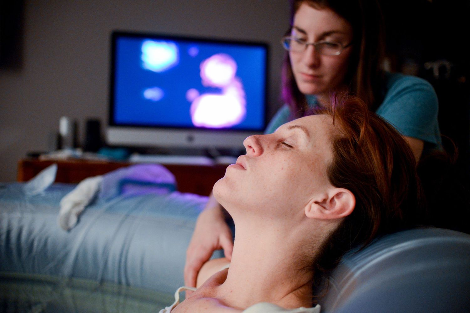 A person receives a medical examination or massage treatment while lying on a table in a clinical setting.