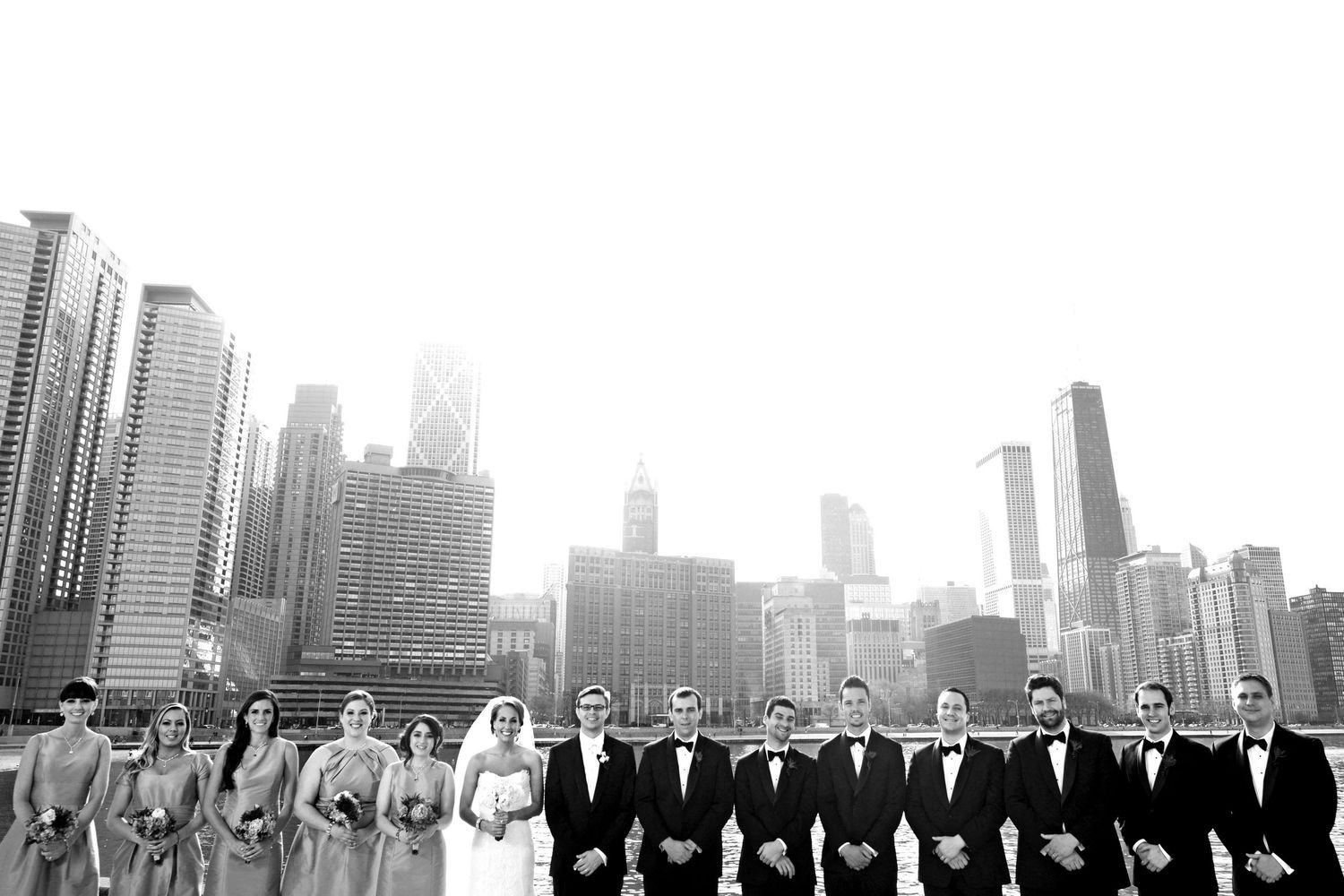 Black and white panoramic cityscape of Chicago skyscrapers and skyline silhouetted against a cloudy sky.