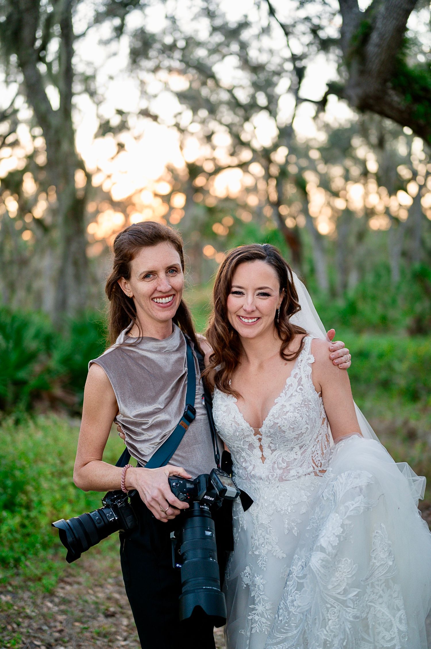 Wedding photographer Samantha Moore with So Many Moments wedding and professional camera poses with bride in lace dress outdoors at sunset.