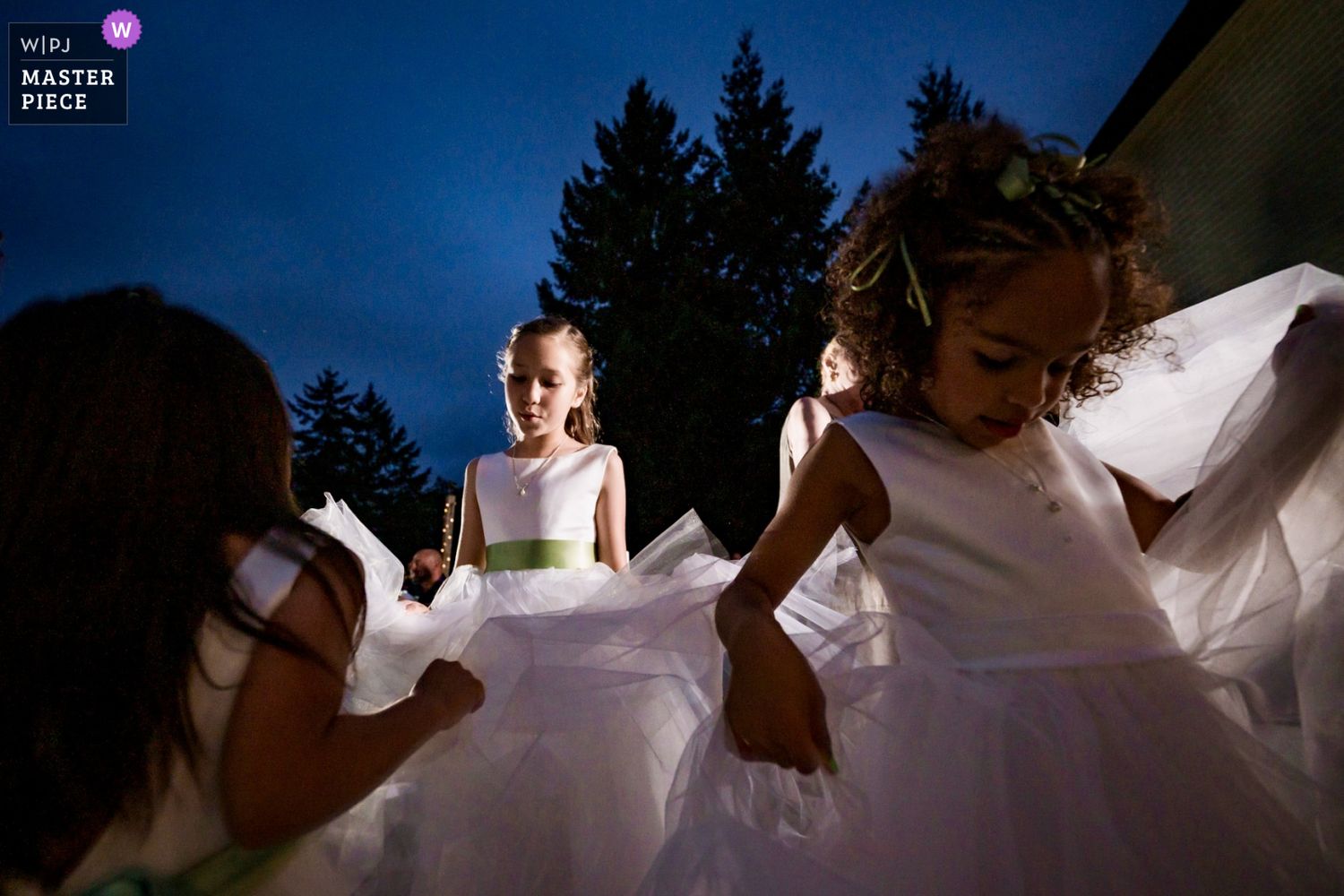 Kids in white dresses twirling and dancing together during a wedding reception, award winning documentary wedding photo