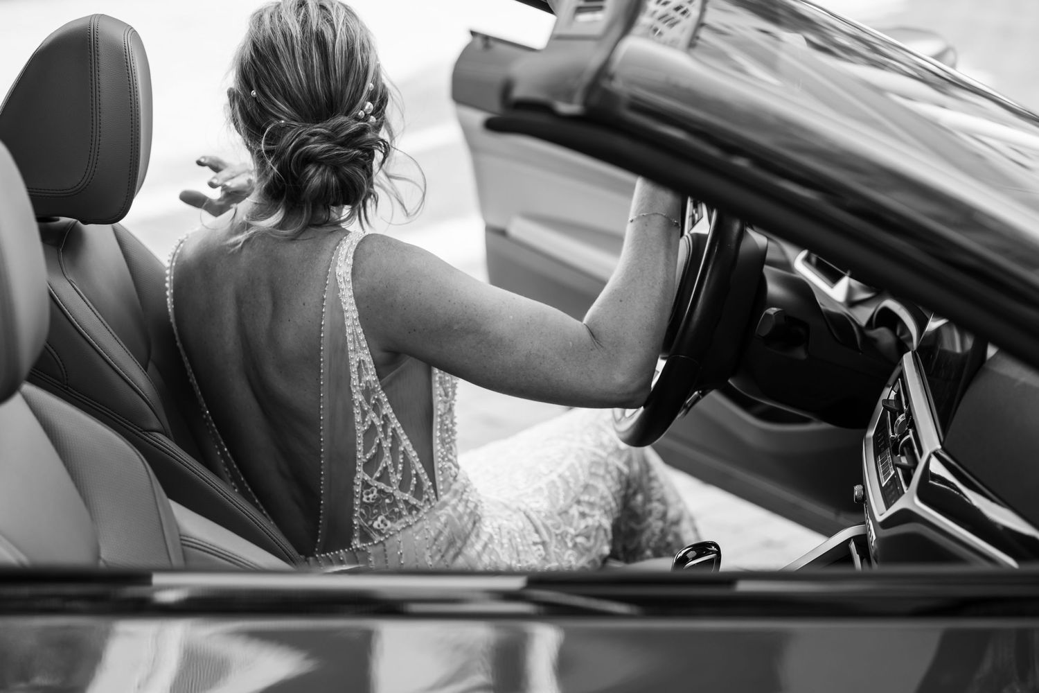 Close-up details of bride in car showing lace dress and natural lighting.