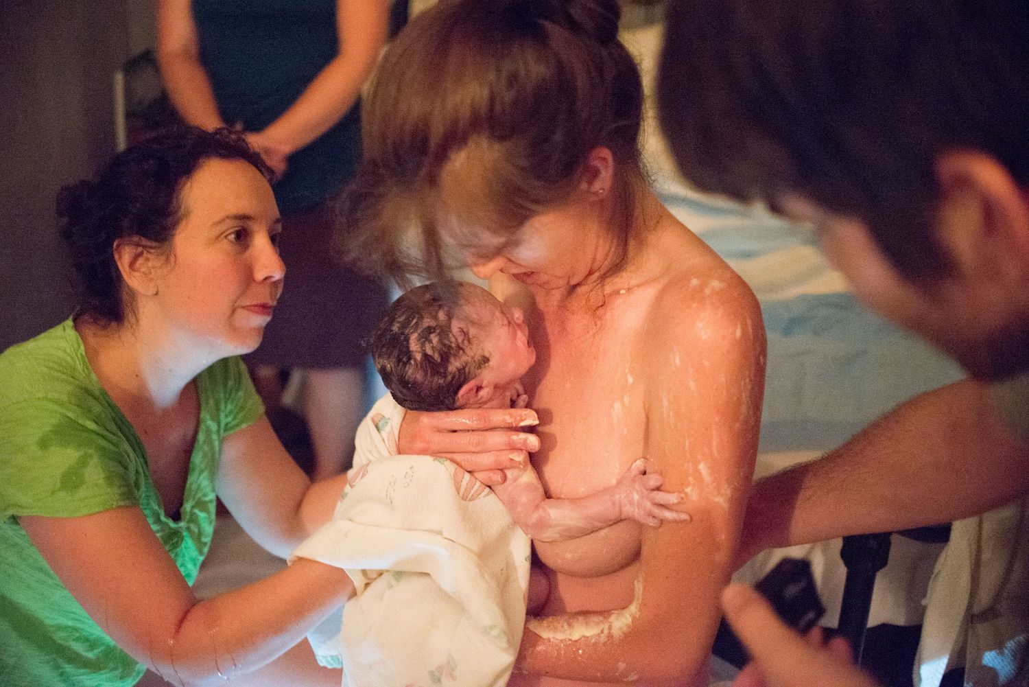 Tender moment as a newborn baby is cradled and kissed in a loving embrace.