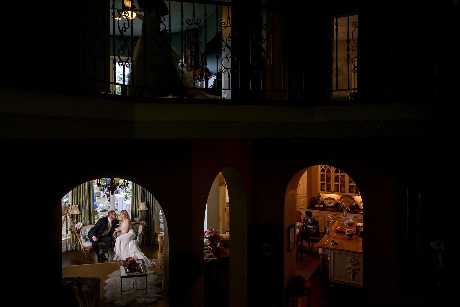 A dimly lit interior scene with dramatic lighting showing silhouettes and shadows in a moody atmosphere.