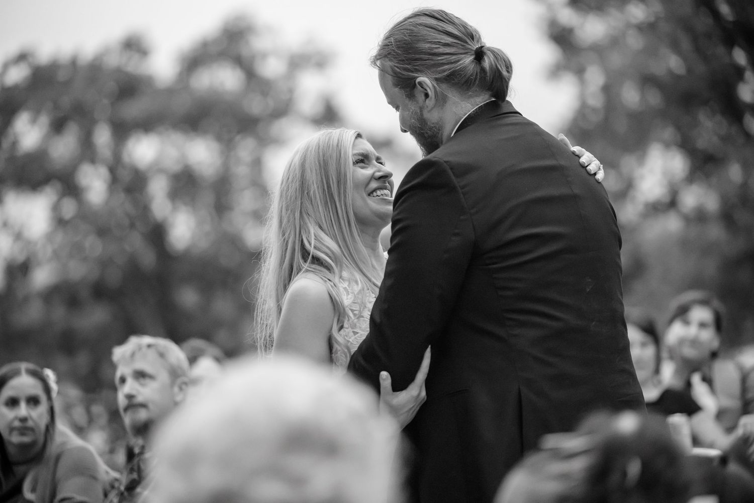 A couple shares a romantic dance together during their wedding celebration in an outdoor setting.