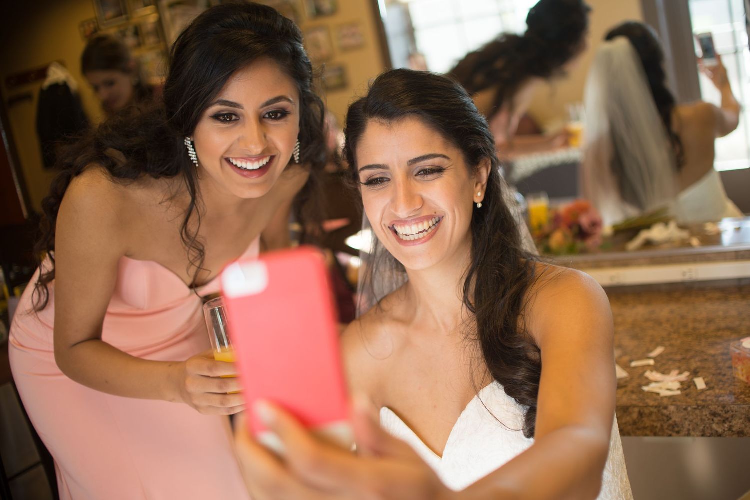 Bride and maid of honor in elegant dresses taking a selfie together getting ready for Pacific Northwest summer wedding ceremony