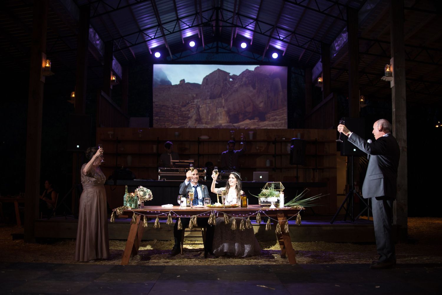 Wedding reception venue with dramatic blue lighting and stage setup.