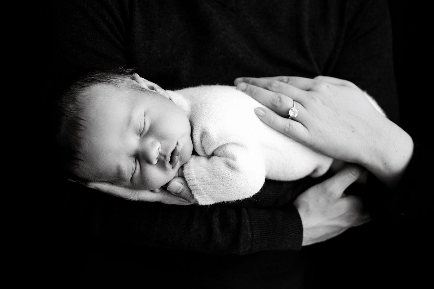 Black and white artistic portrait of sleeping newborn in minimalist style.