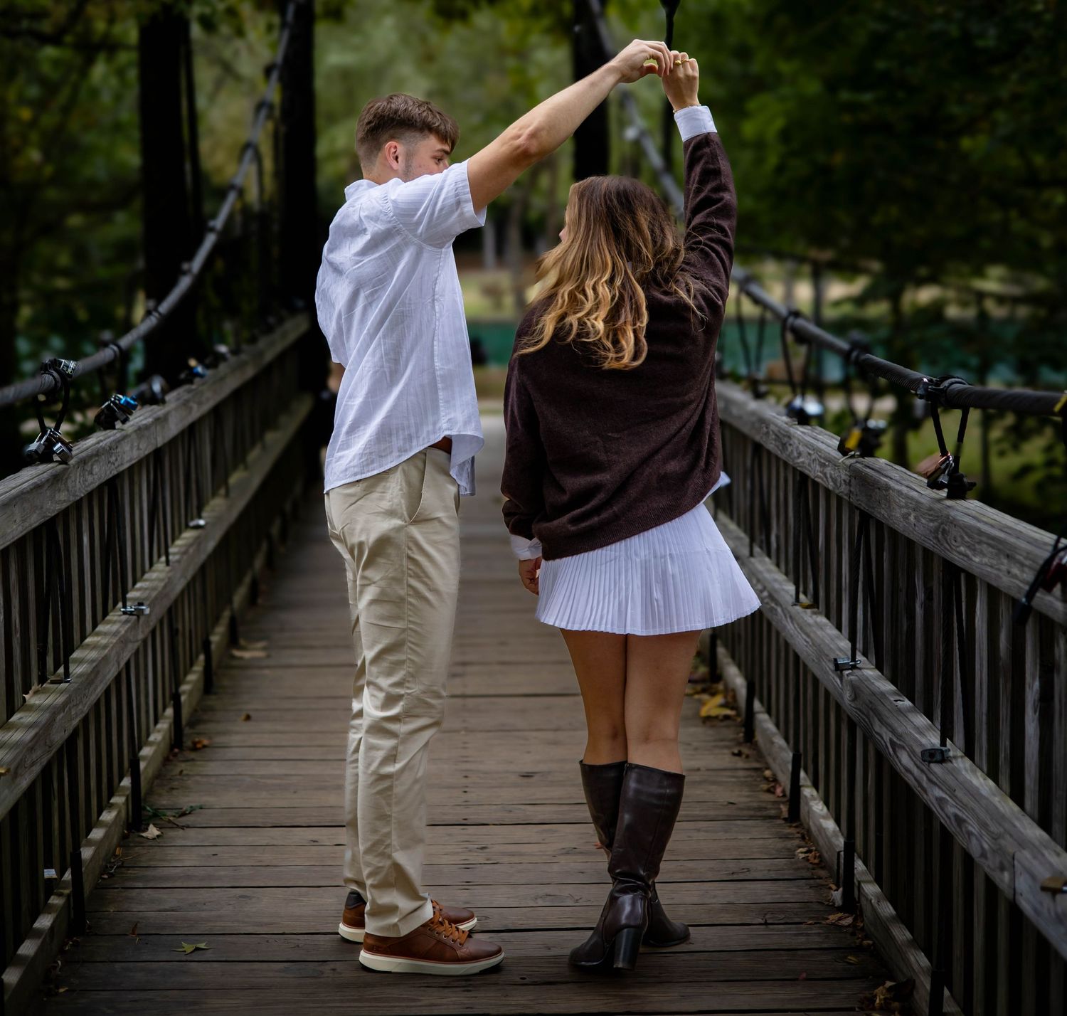 Couple walking hand in hand across a wooden bridge in casual attire, shown in a series of candid moments.