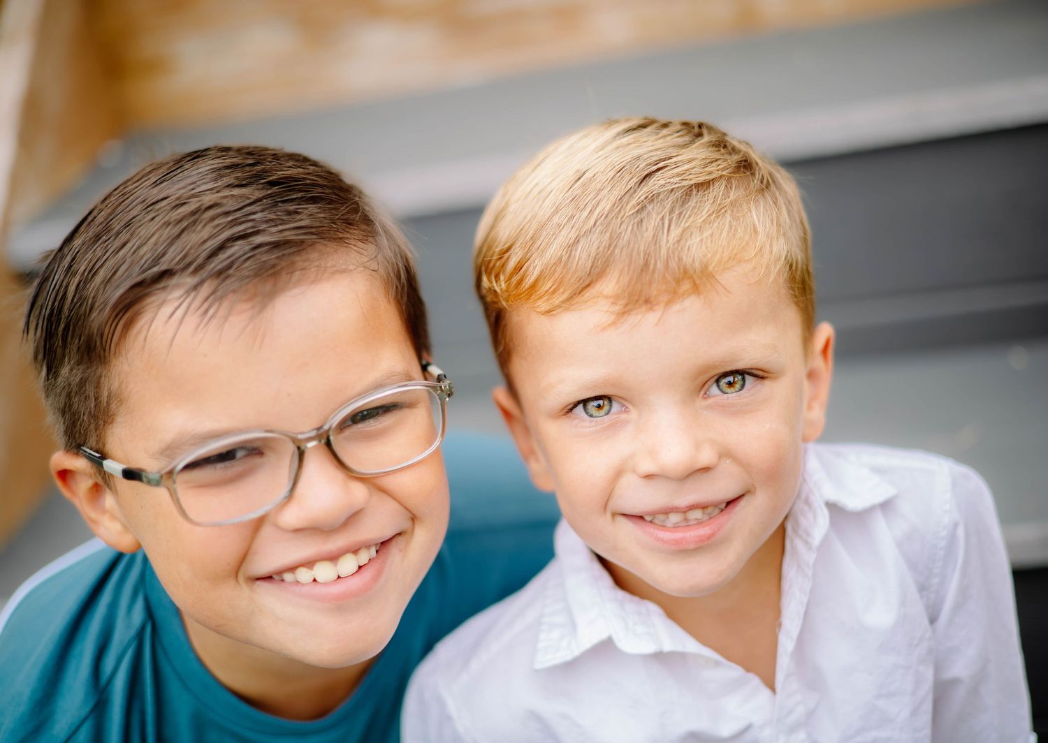 Two young boys smile and pose together for a series of candid portrait photographs.