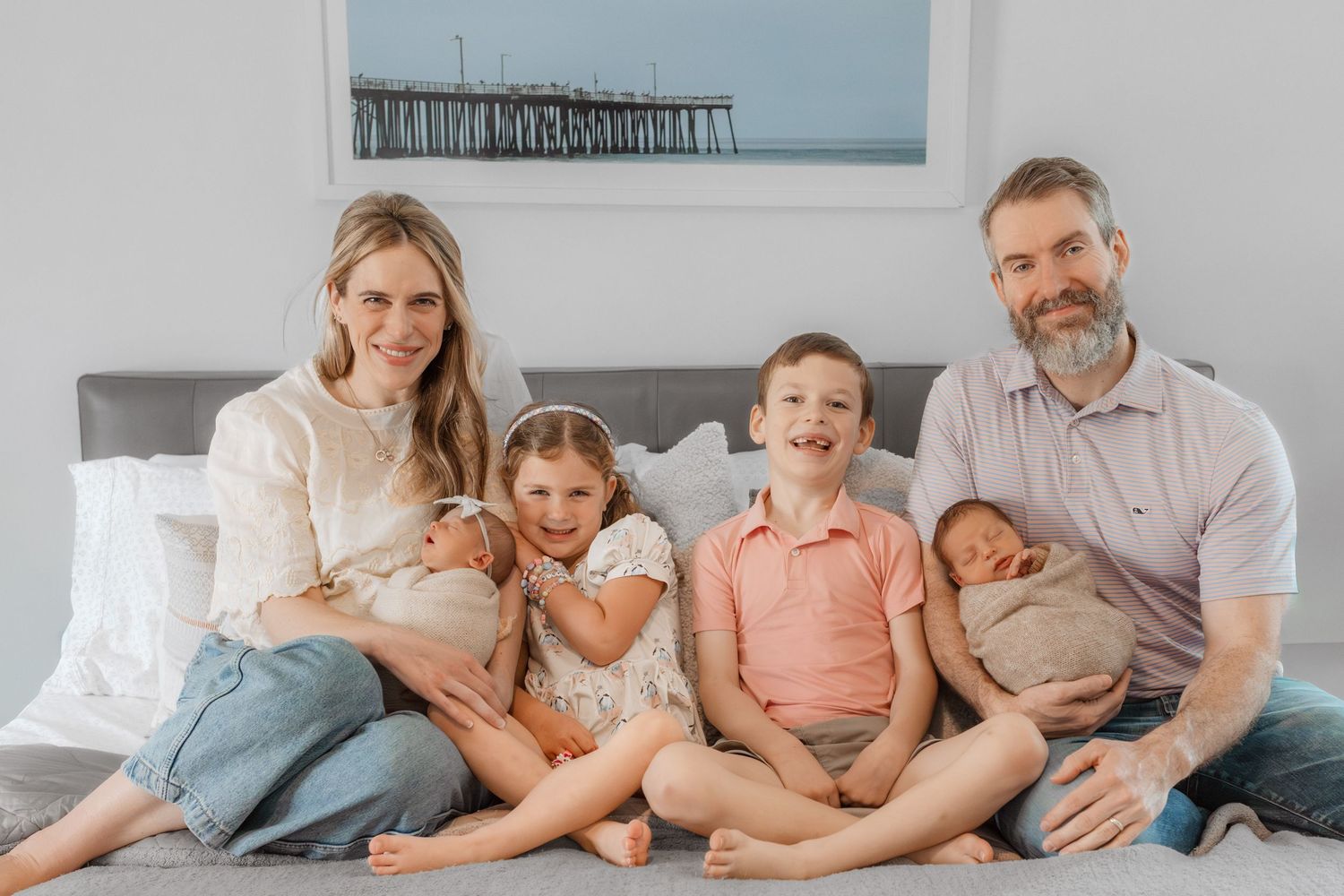 Family members relaxing together on a light gray couch in a cozy living room setting.