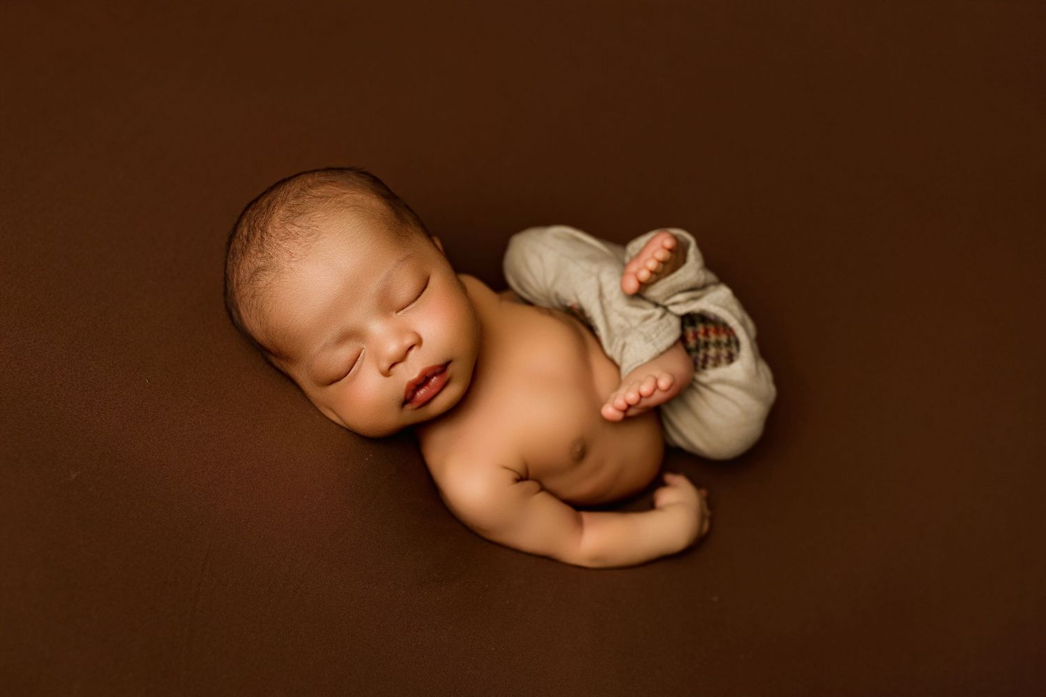 A series of six artistic sepia-toned photographs showing a sleeping newborn baby in various peaceful poses.