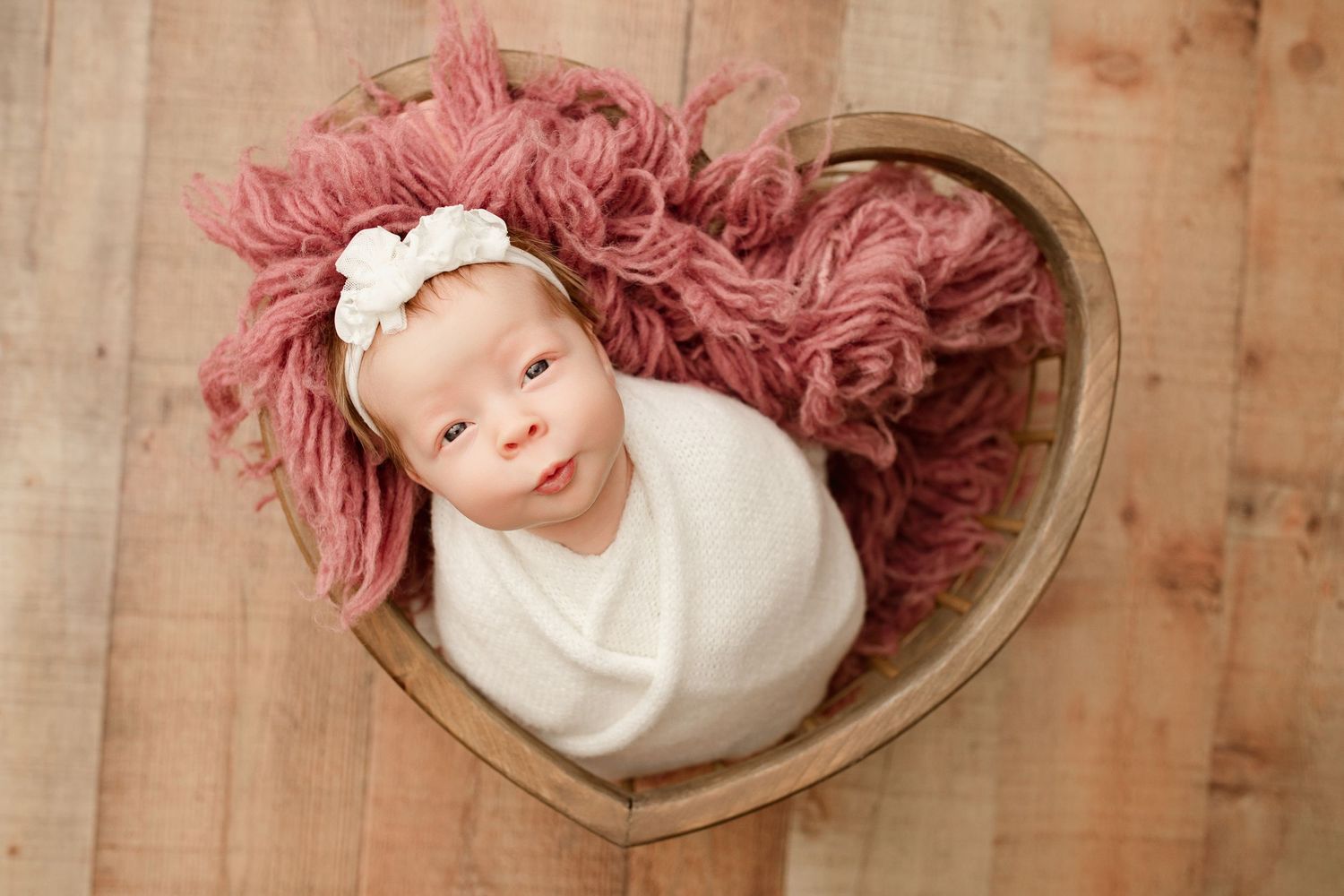 A heart-shaped mirror collage shows a person with pink hair wearing white against a textured beige background.
