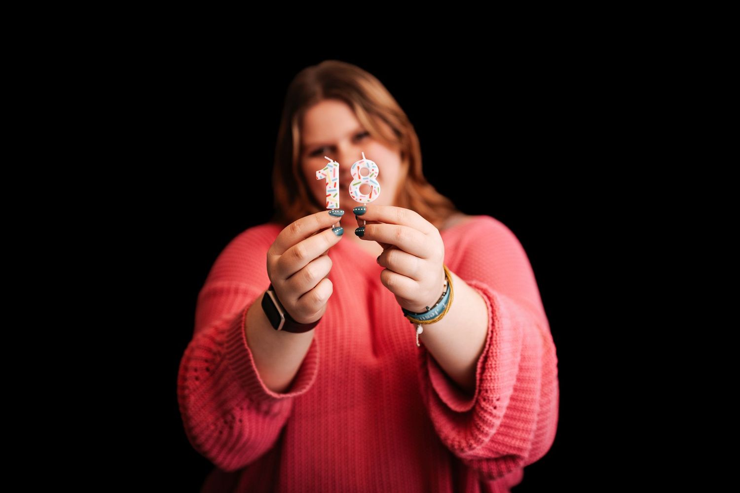 Person in coral sweater demonstrates sequential steps of using a smartphone against dark background.
