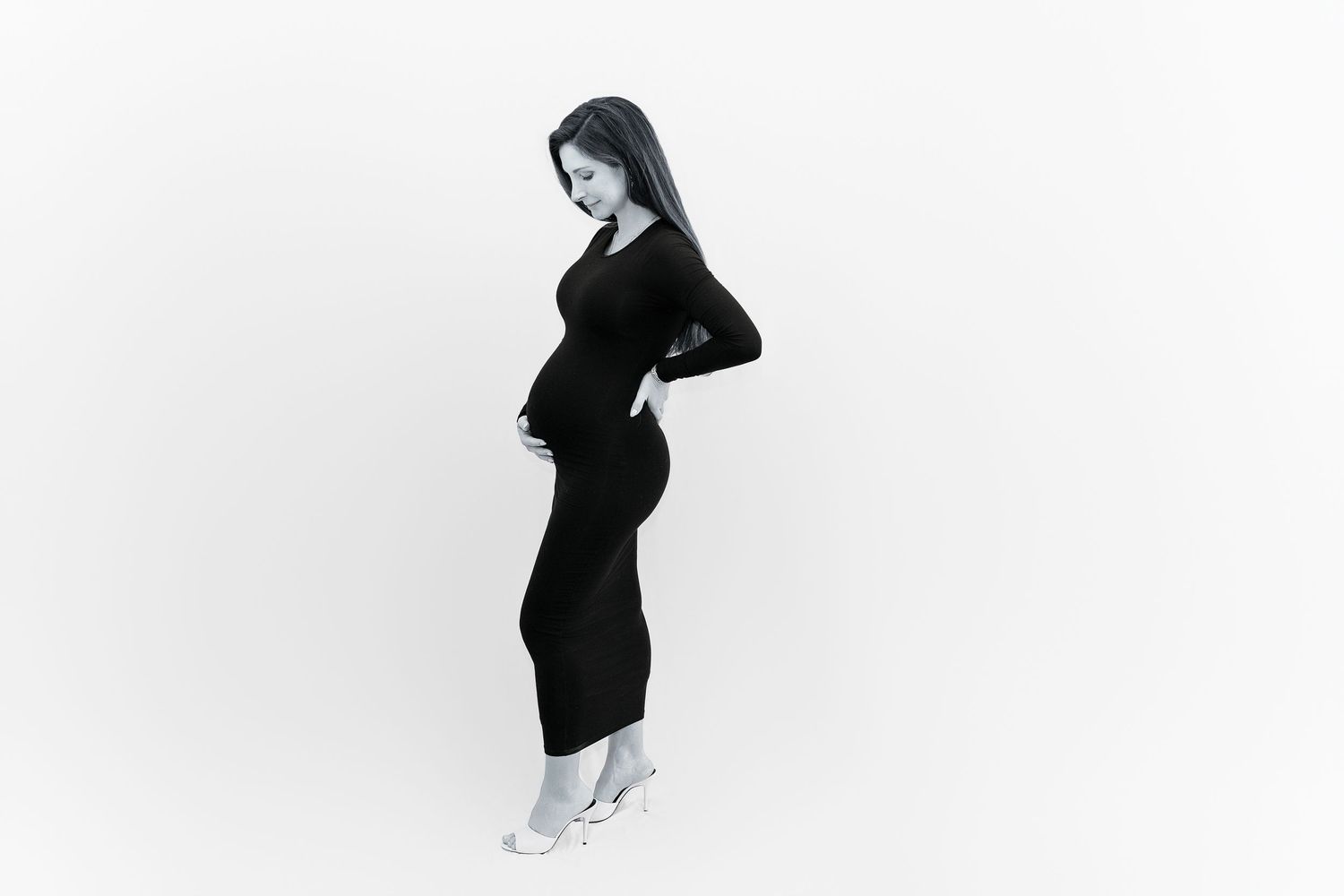 A silhouetted figure in black clothing stands against a white background.