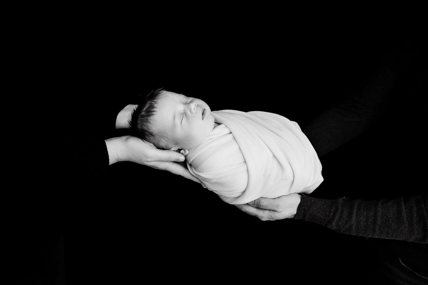 Minimalist black and white newborn photography with simple poses.