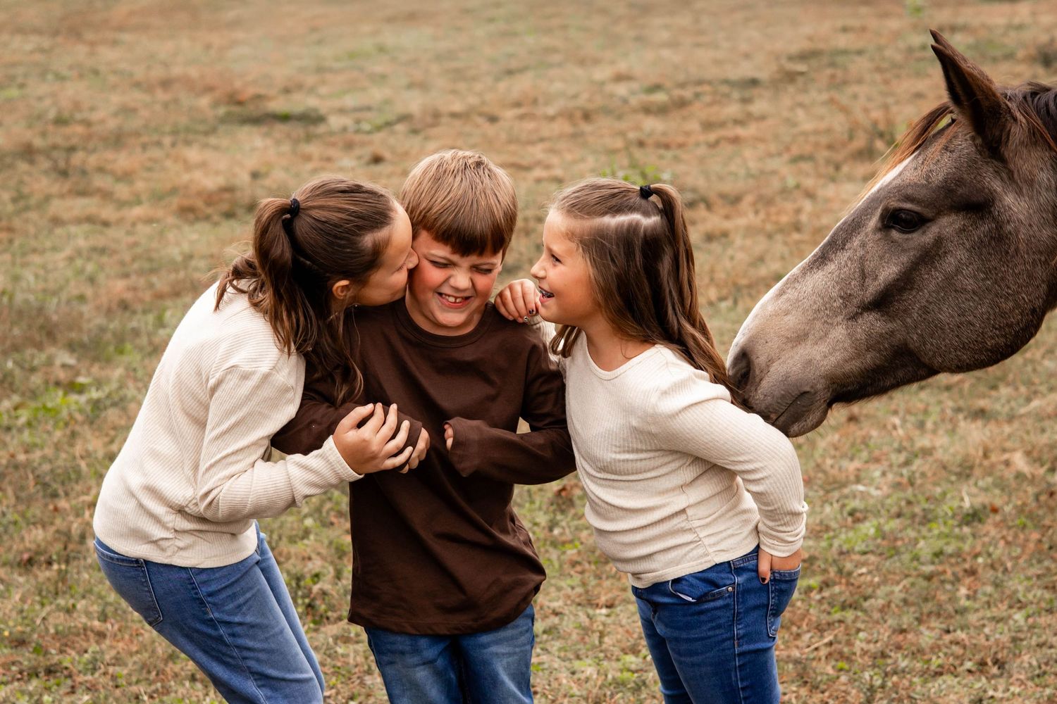 A series of candid photos showing playful interactions with a dark horse in a grassy field on an autumn day.