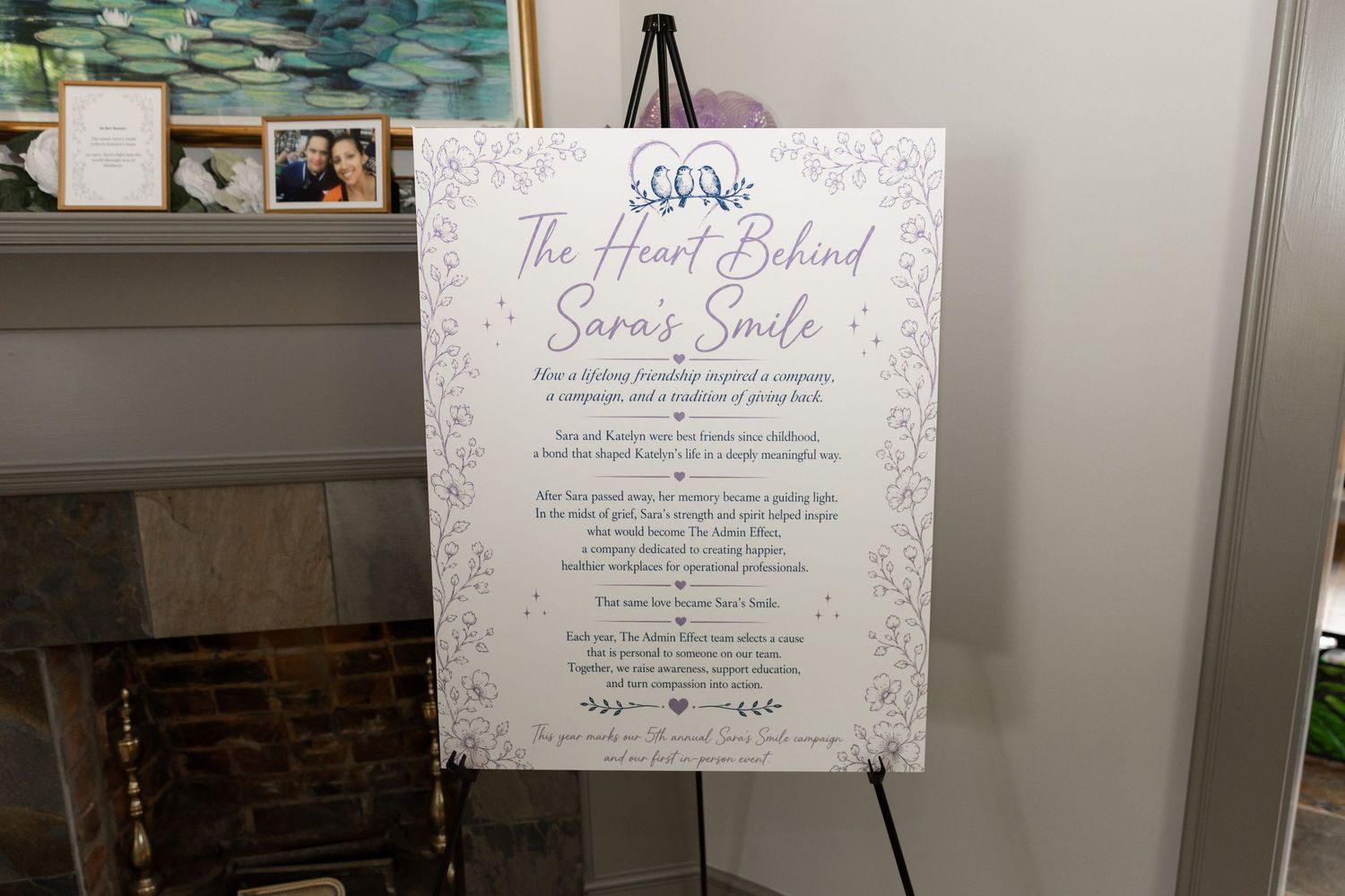 Elegant event sign on easel reading The Heart Behind Sara's Smile at a charity fundraiser gathering.