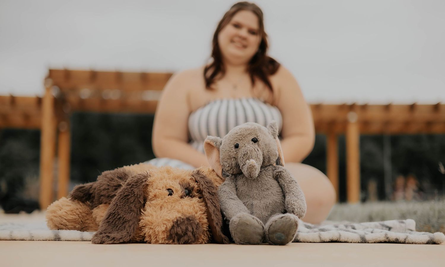 A series of teddy bears lined up on a wooden surface with a blurred background.
