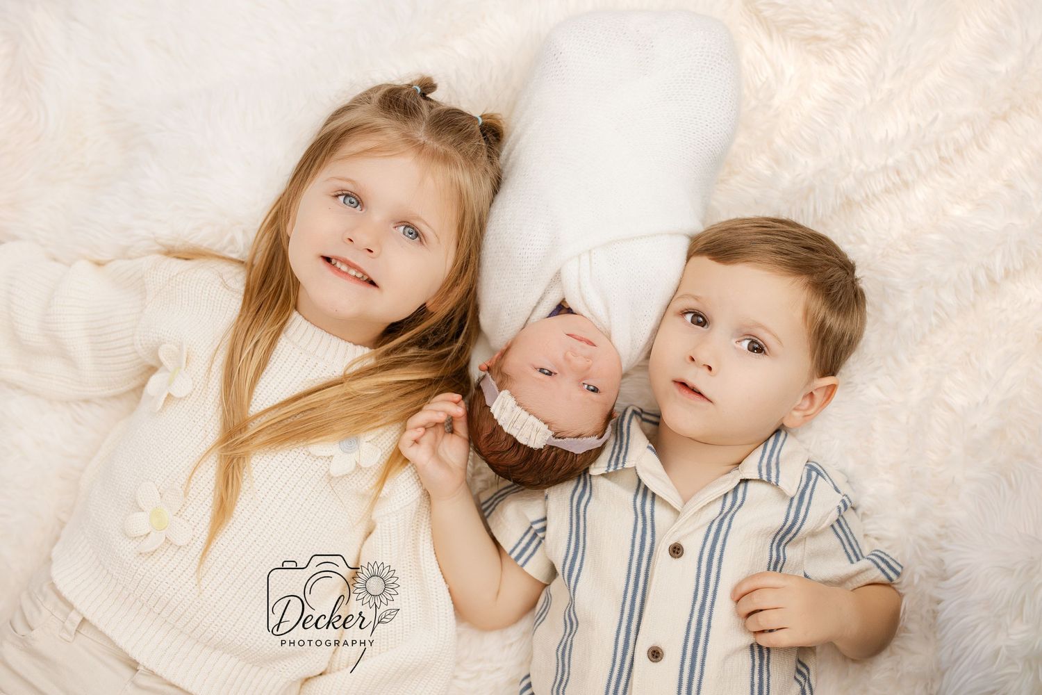 Two children in coordinating blue and white striped outfits pose together for a series of sweet sibling portraits.