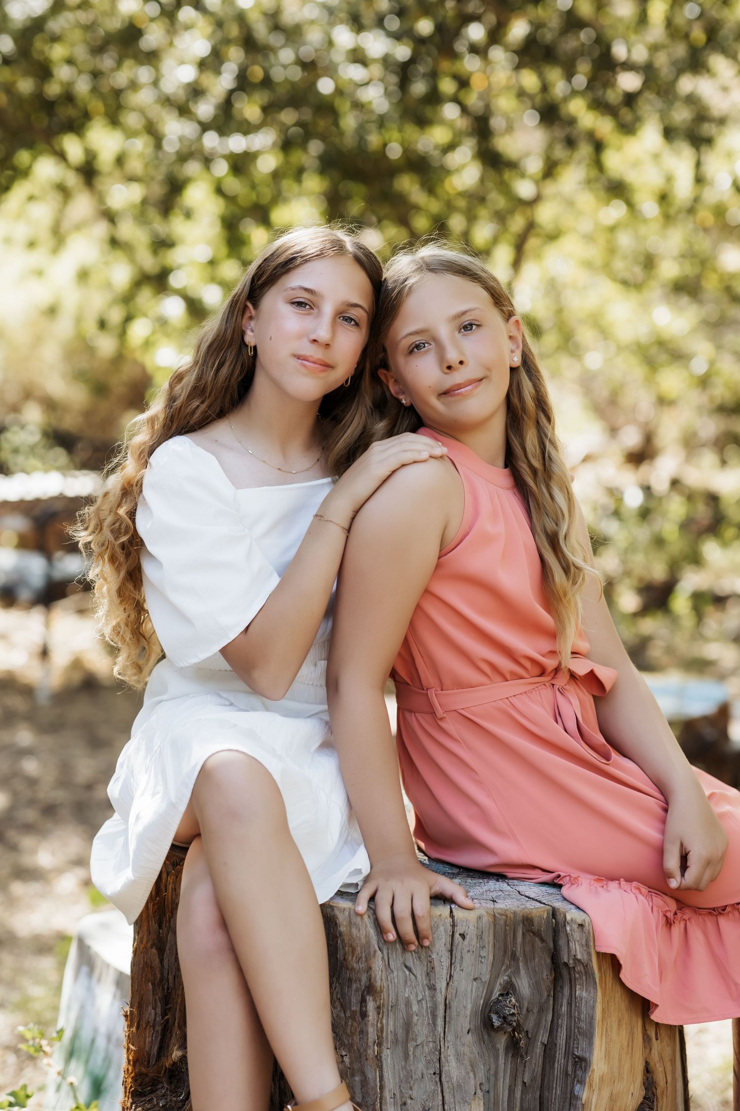 Sisters sitting next to each other leaning into each other during a relaxed family portrait session in Orange County