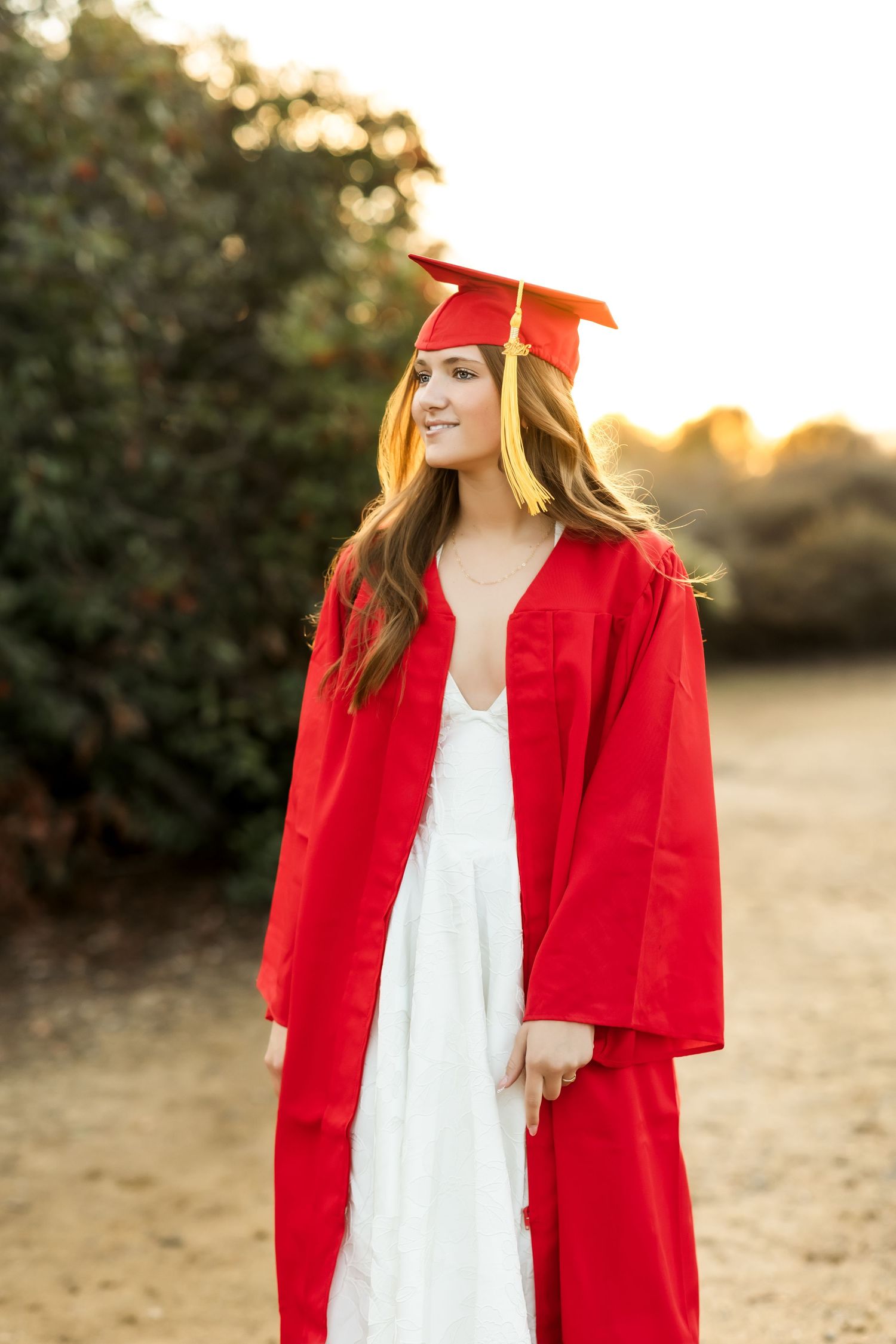 Fullerton grad session with cap and gown on a trail at sunset