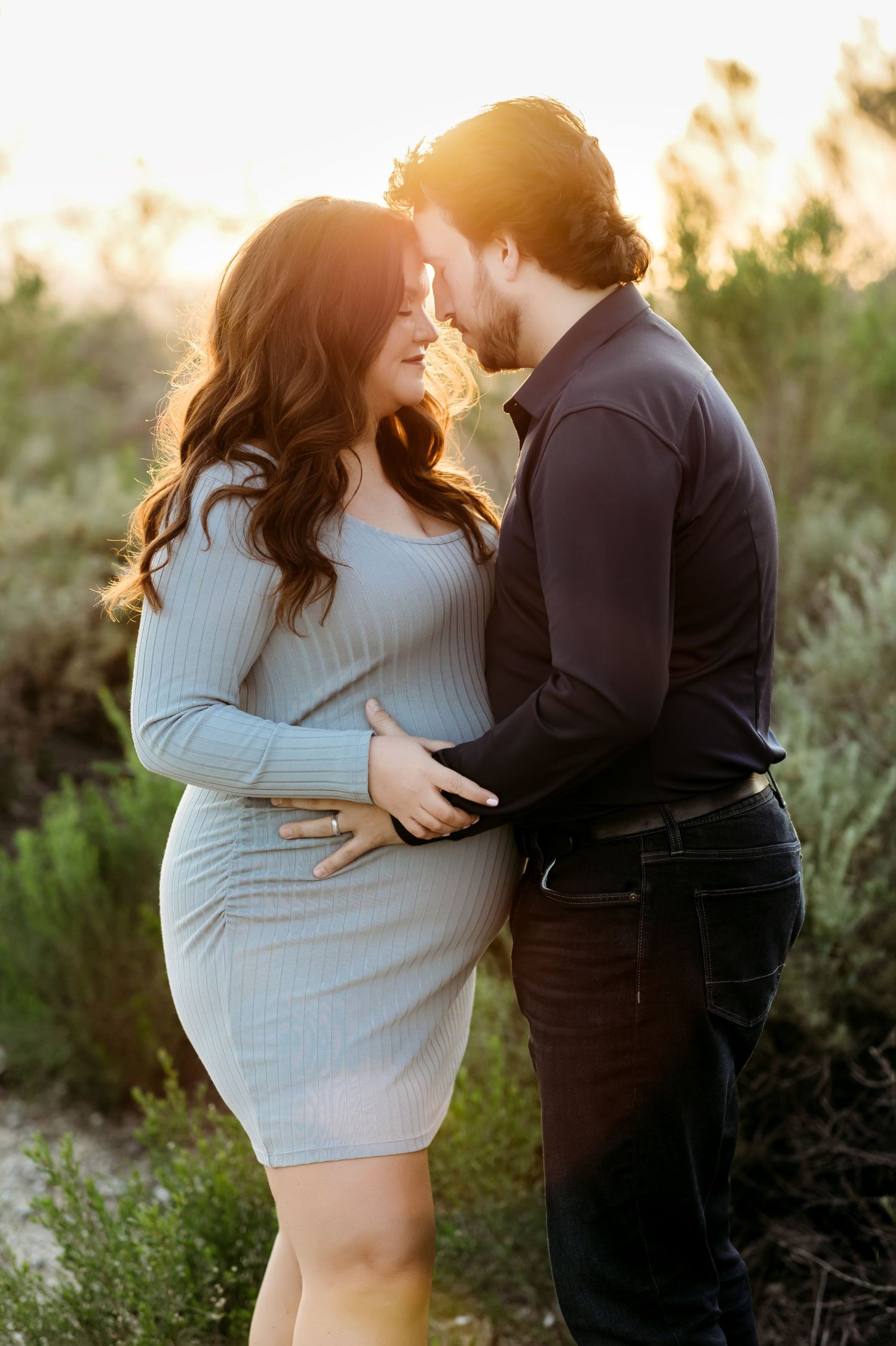 Couple forehead touch during an intimate outdoor maternity photo  session