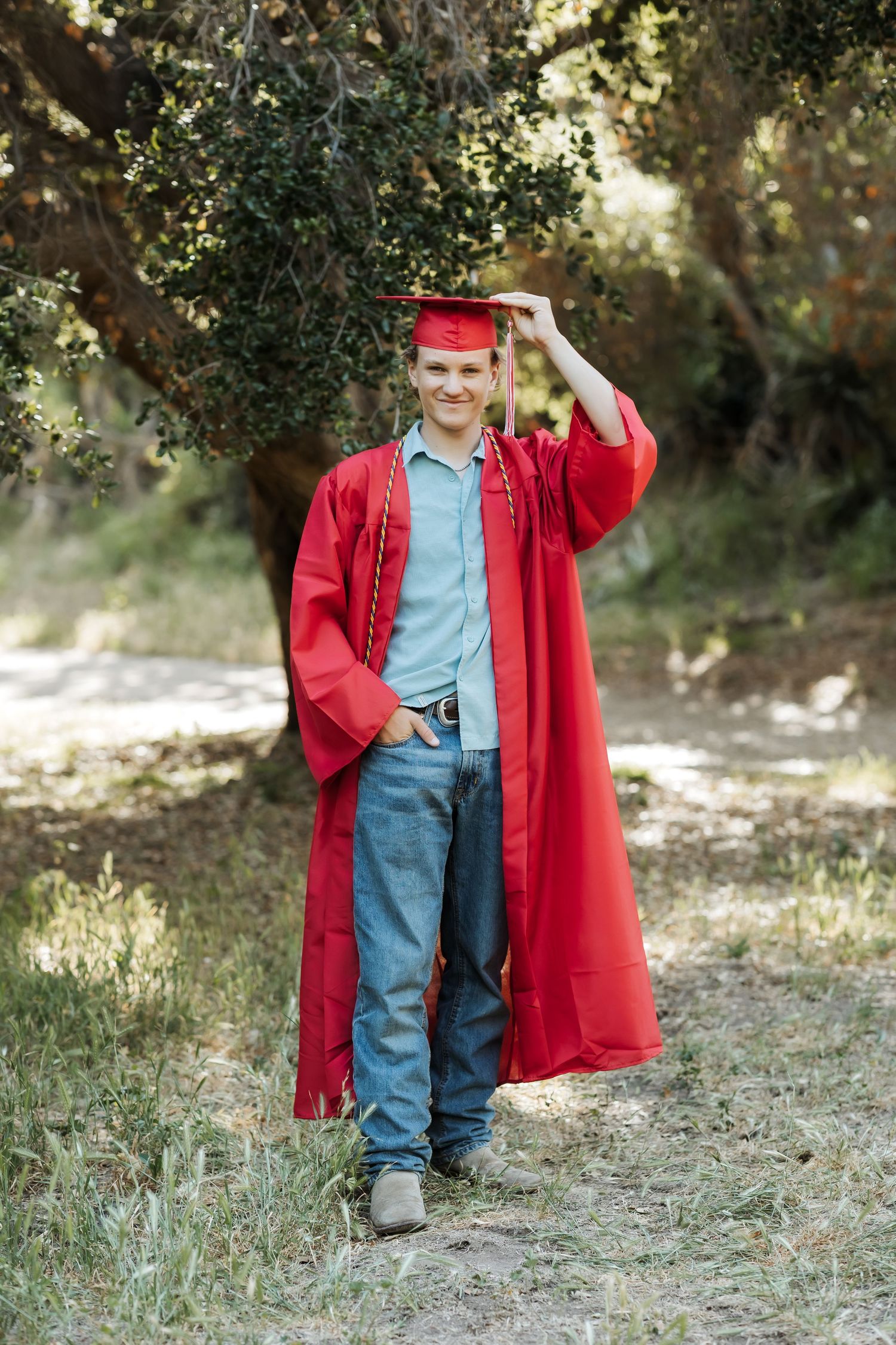 Graduate walking toward camera laughing during outdoor session