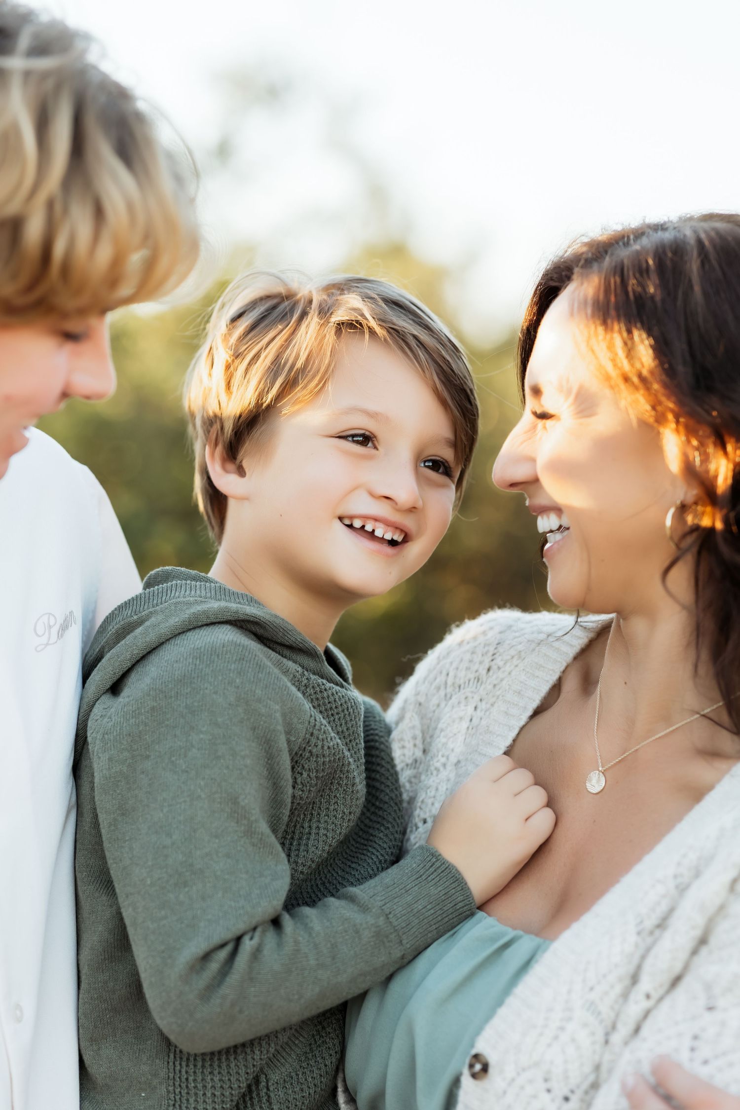 Candid laughter of mom holding little boy during outdoor family photo session in Orange County