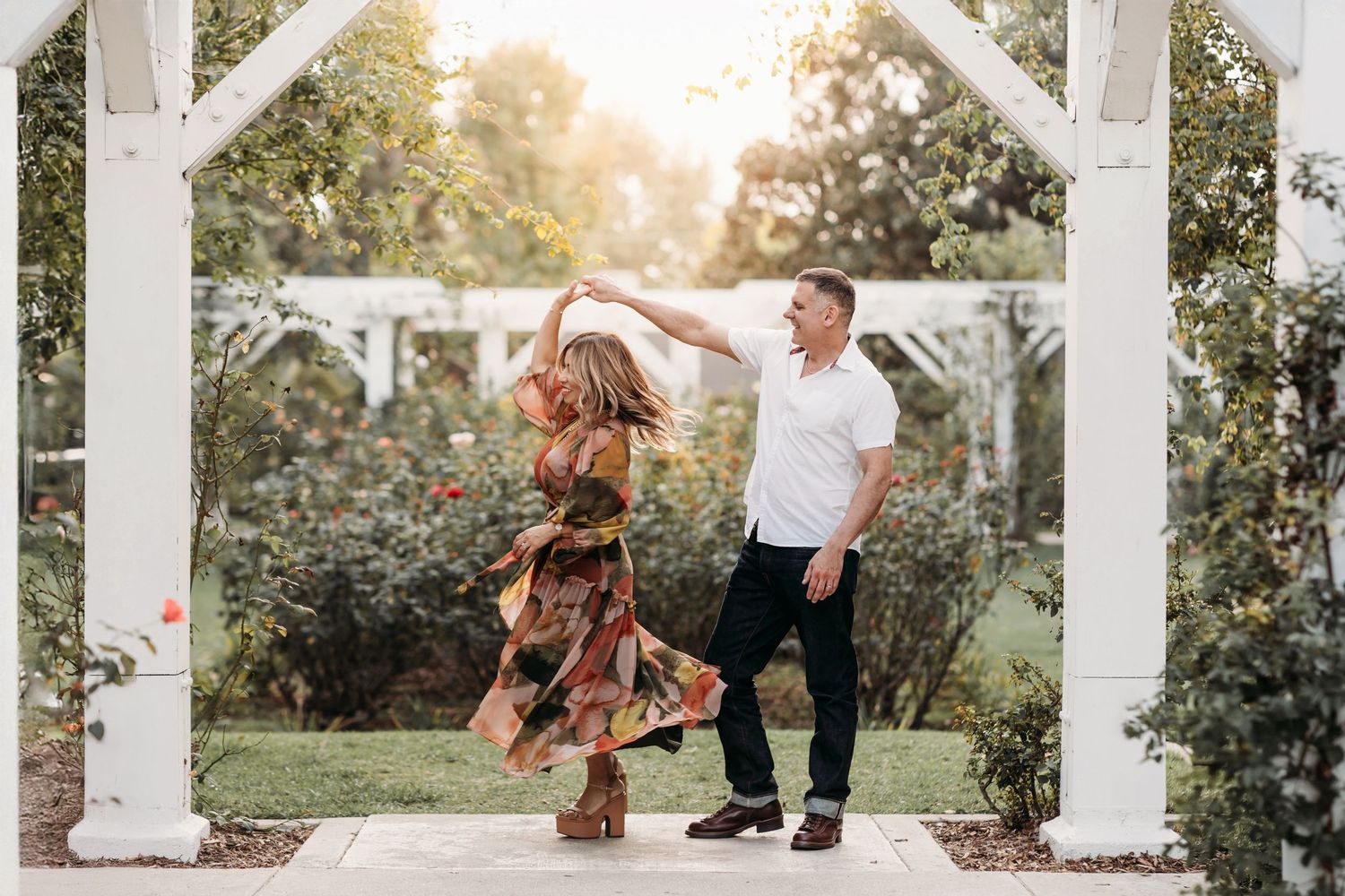 Orange County couple twirling during family photo session with flowy dress