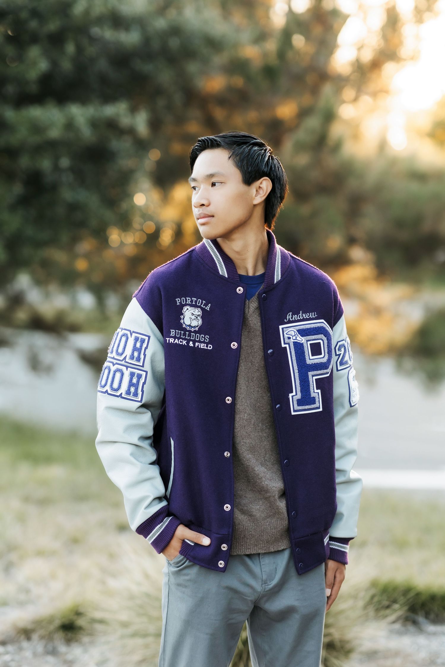 Graduating senior in letterman jacket during a sunset grad portrait session in Orange County