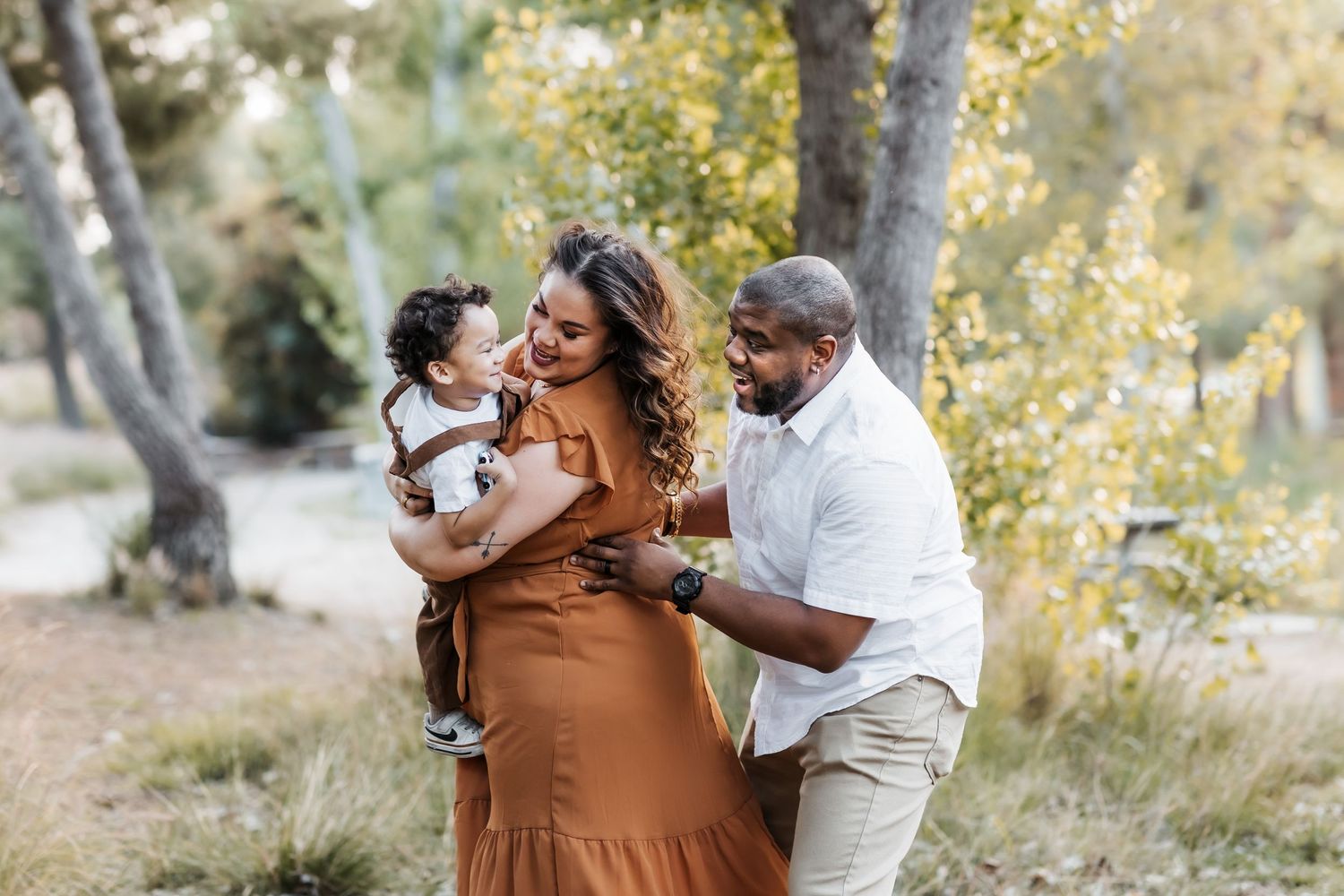 candid family photo parents holding toddler laughing