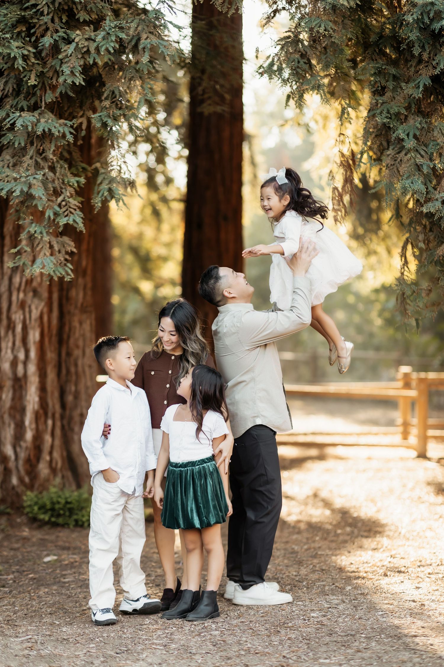 A family smiling and laughing looking at one another during a relaxed family portrait session in Brea, CA
