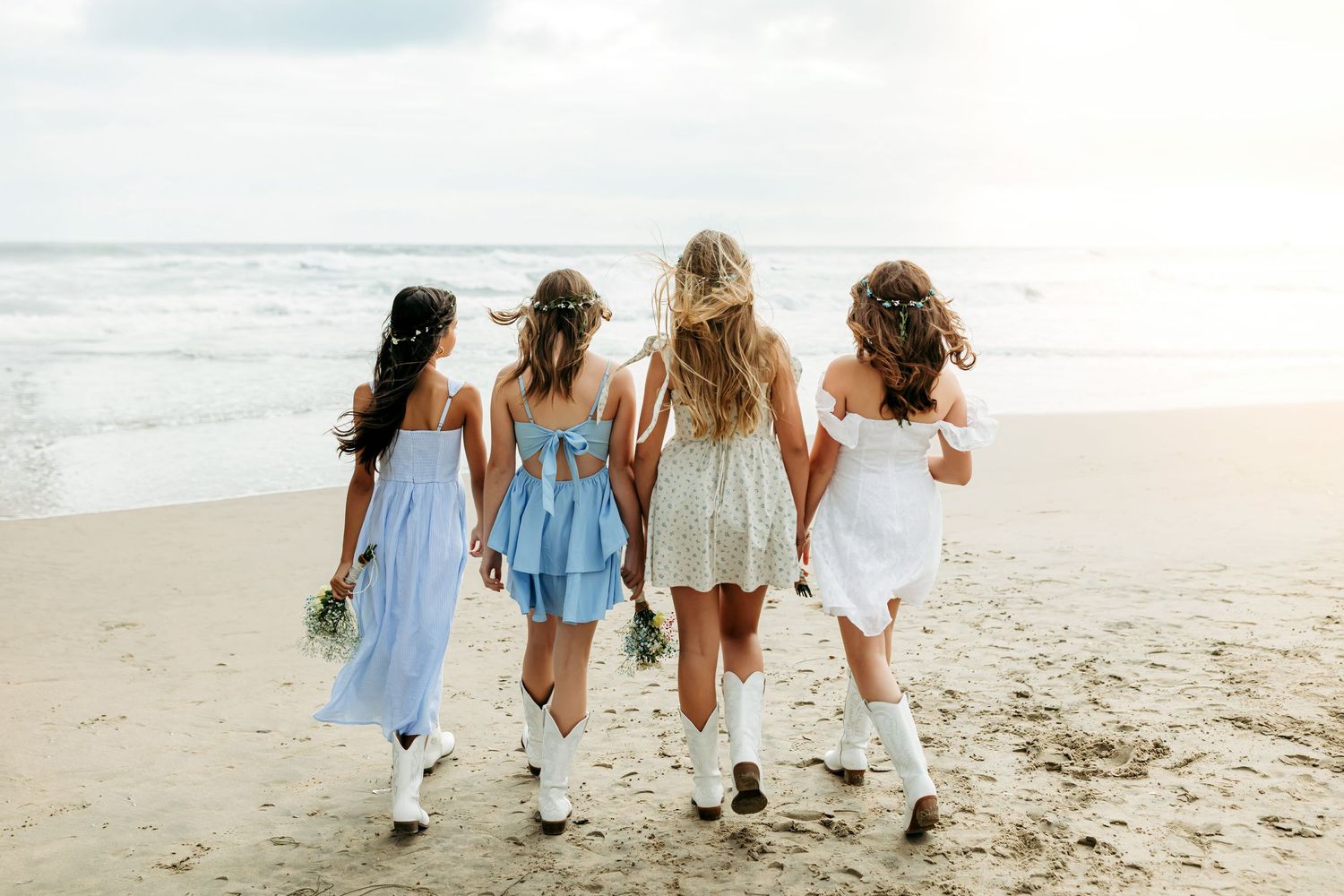 Friends celebrating graduation while walking along the beach with wind in their hair