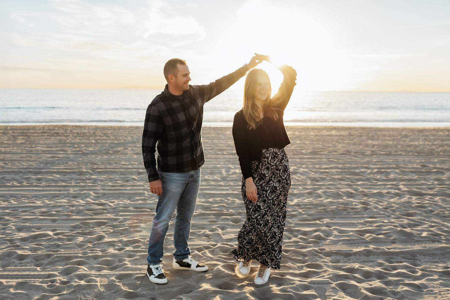 Couple dancing together on the beach during sunset photo session
