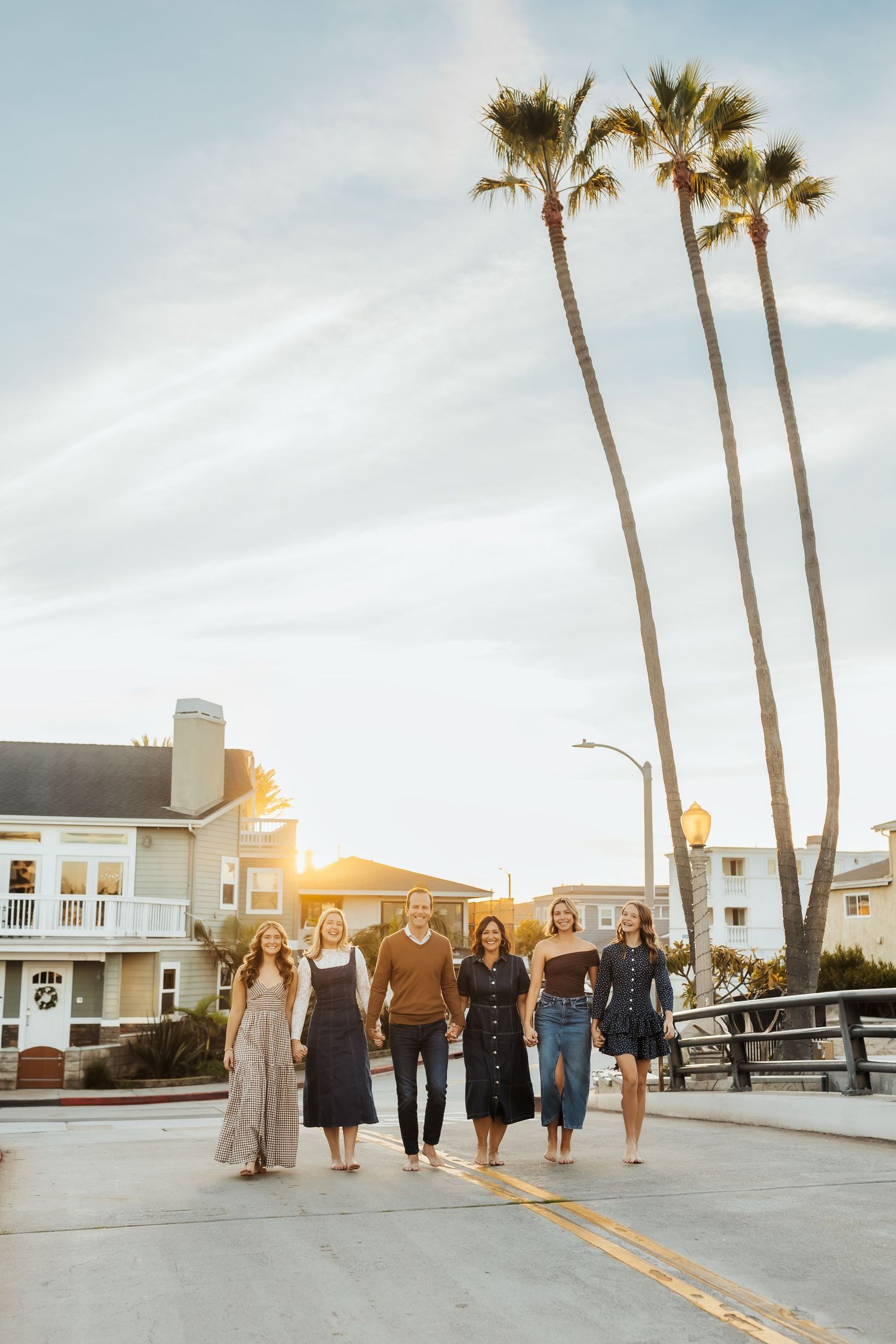 Family walking over a Newport Beach Bridge during a sunset family session